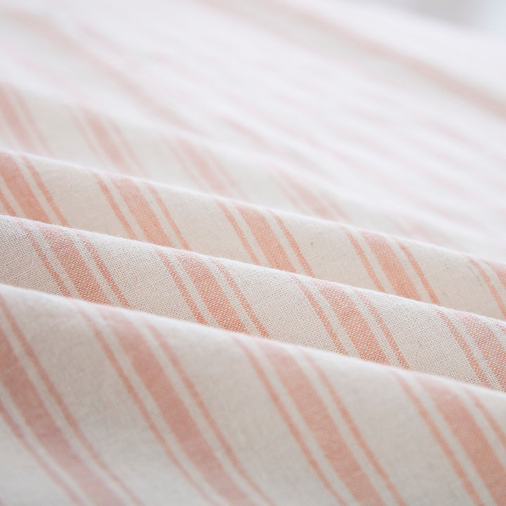 Close-up of the tactile lived-in texture and richer color depth of the yarn-dyed blush pink striped sheet fabric - DAUAOTO