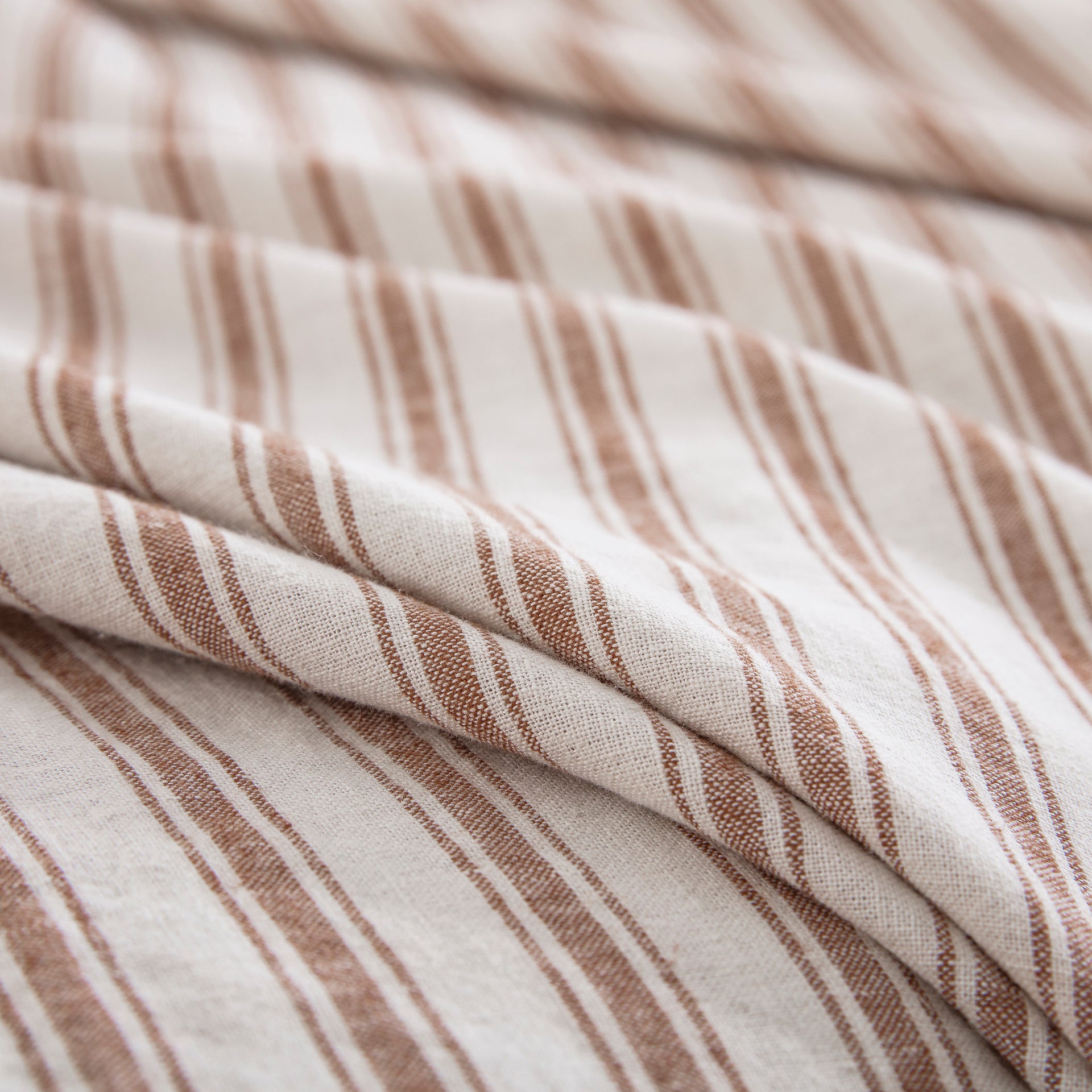 Tactile rustic texture of the 55% European flax linen and 45% natural cotton blend in caramel stripe - DAUAOTO