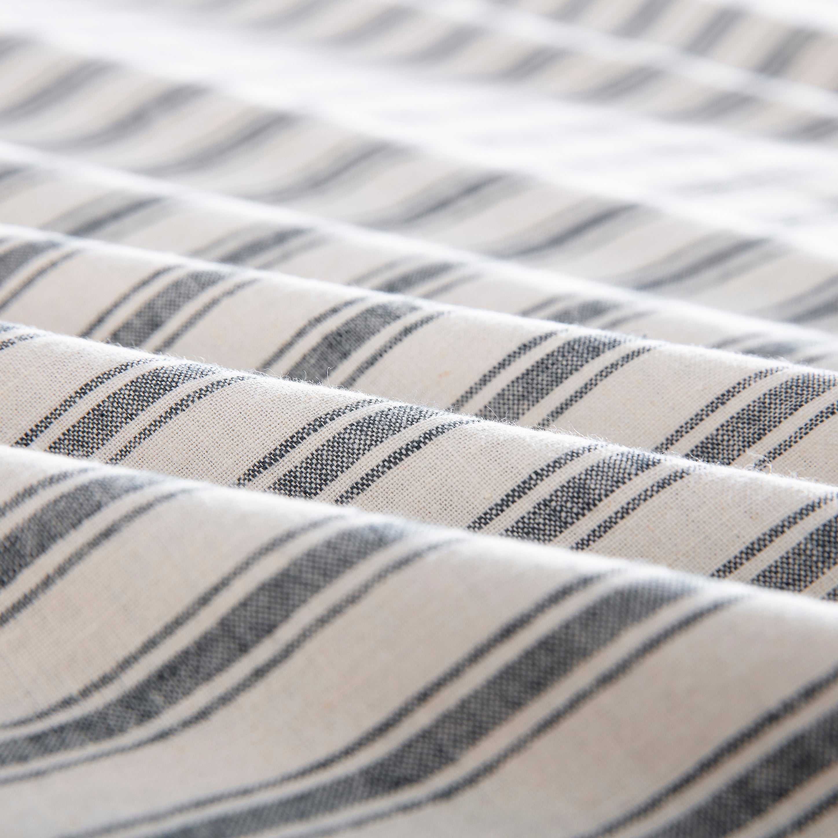 Close-up of the tactile lived-in texture and exceptional color depth of the yarn-dyed classic grey striped fabric - DAUAOTO
