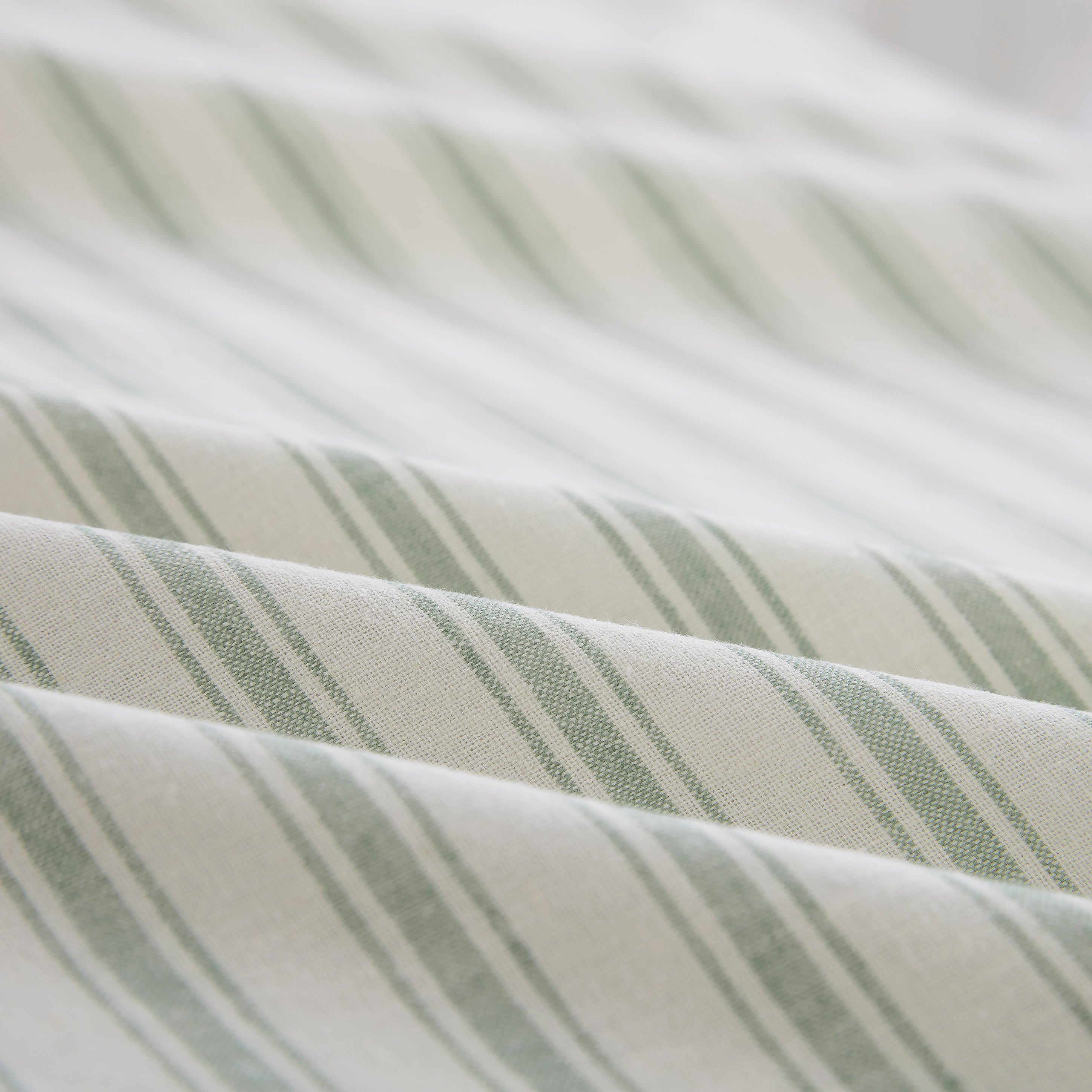 Close-up of the wonderfully tactile lived-in texture and refreshing visual depth of the yarn-dyed sage green striped sheet fabric - DAUAOTO