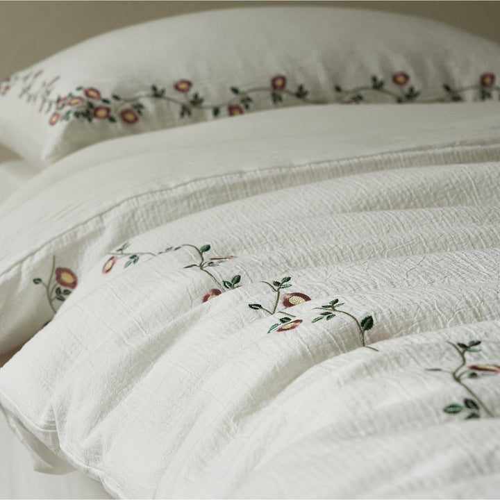 Delicate floral vines embroidered across the Briar Bloom washed cotton duvet cover