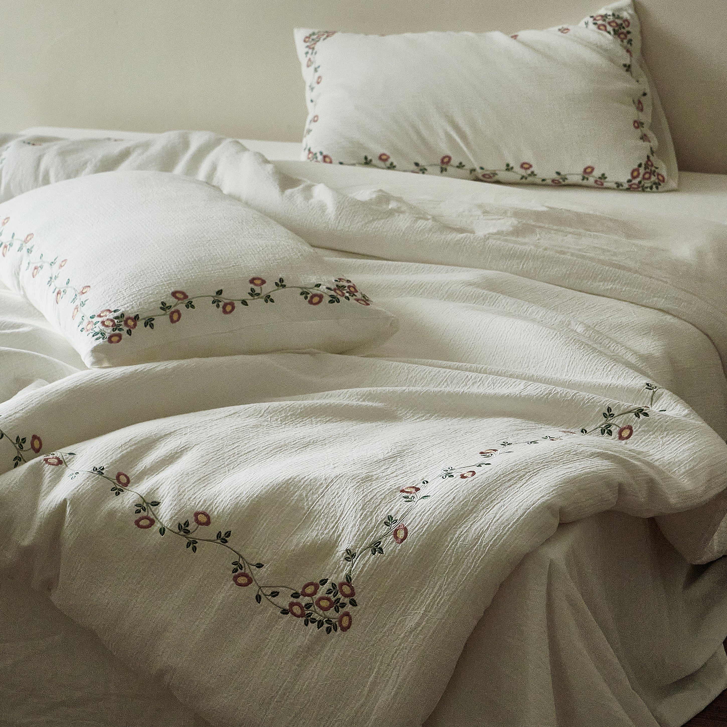 Briar Bloom embroidered duvet cover naturally draped across a relaxed bed