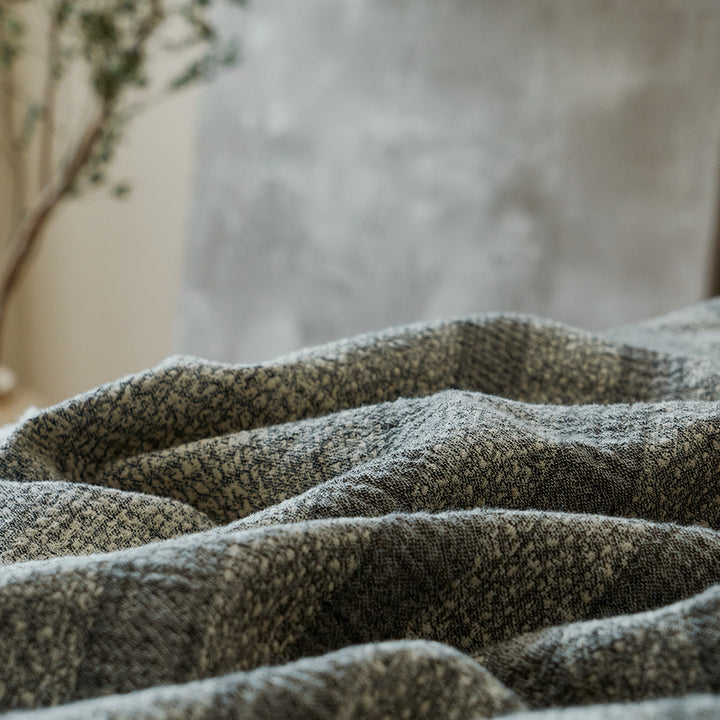 Close-up of the breathable charcoal black linen blend fabric showing its striped pattern and crinkle texture.