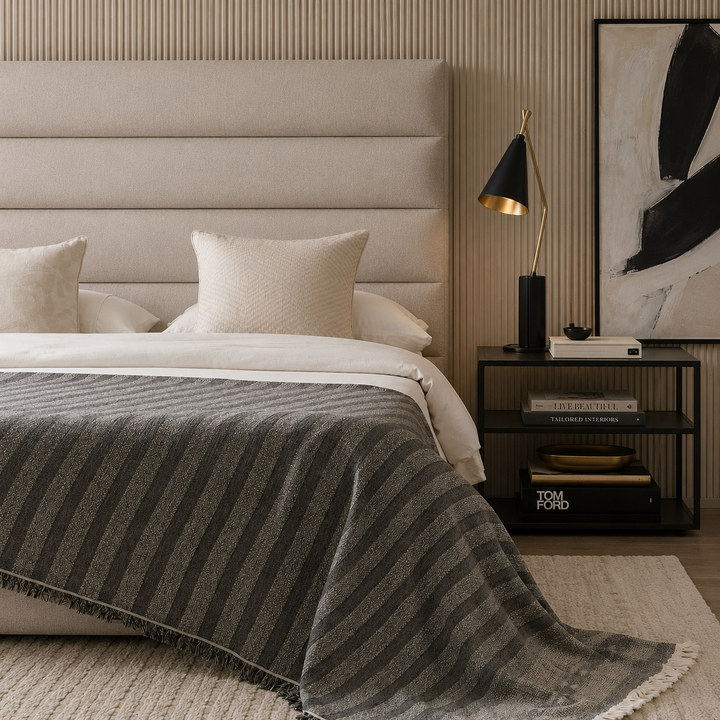 Large charcoal black striped cotton-linen throw used as a summer bedspread on a minimalist bed.