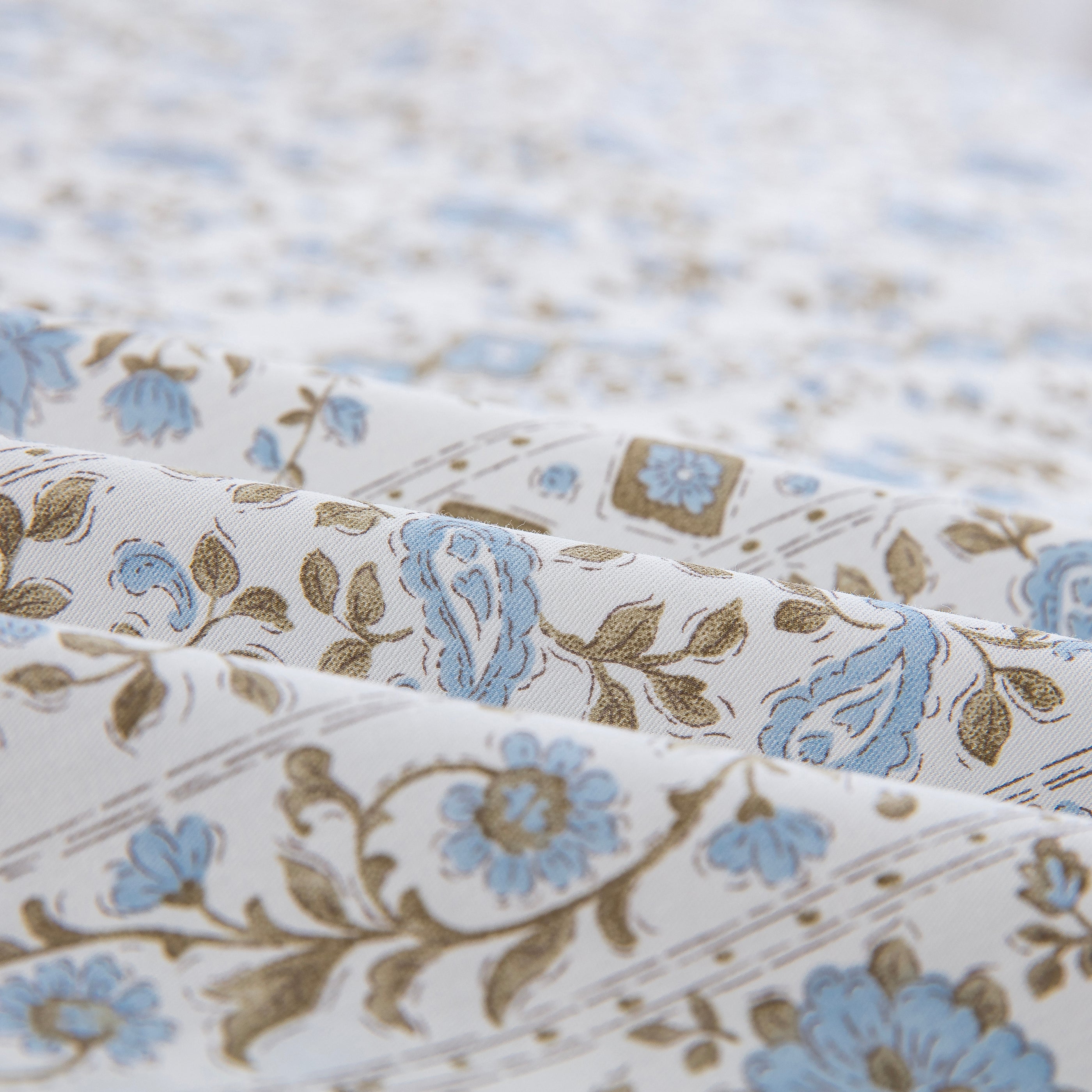 Folded DAUAOTO coastal blue block print cotton bed sheets highlighting the breathable, smooth, and lightweight fabric texture.
