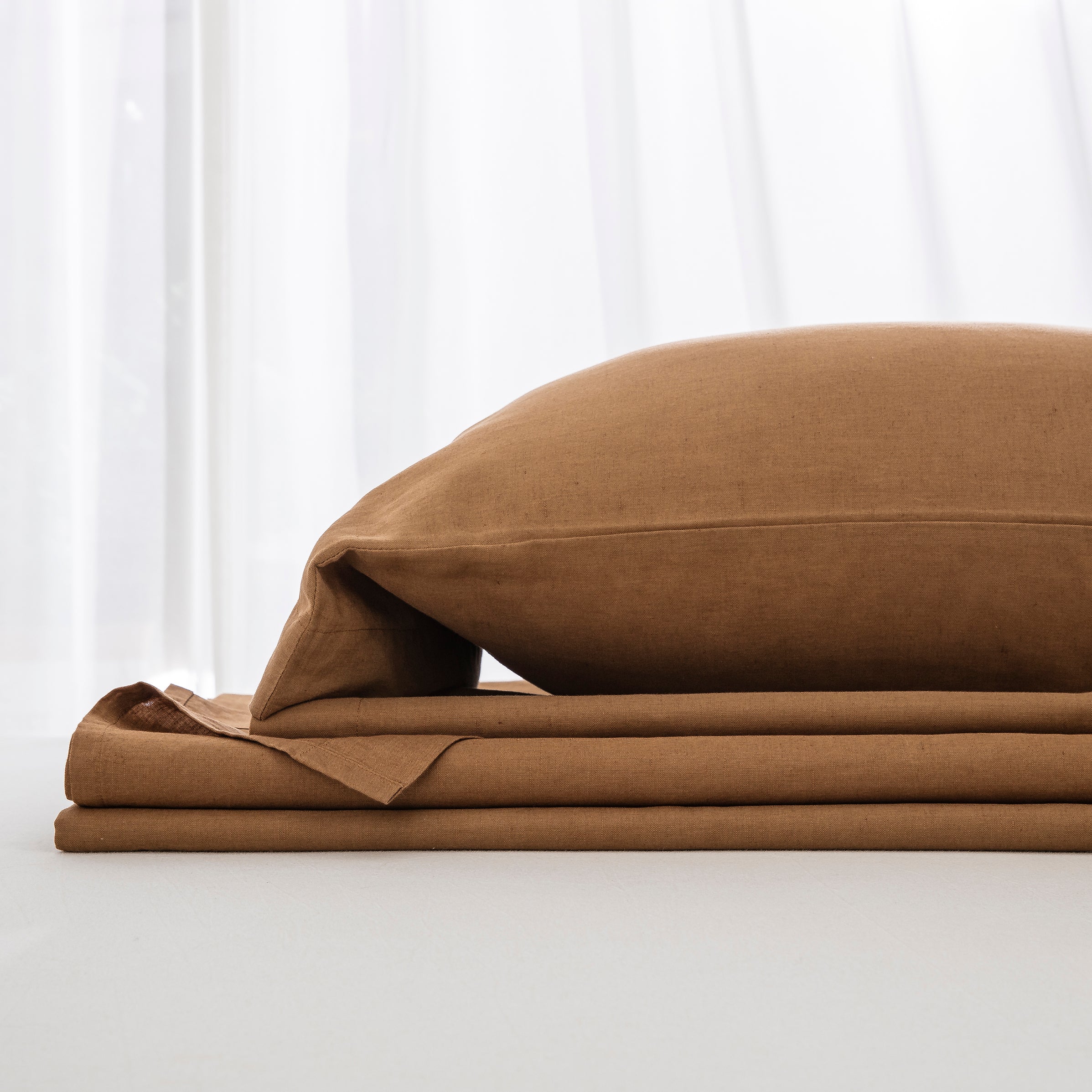 Complete cognac brown linen cotton bedding ensemble folded neatly showcasing an incredibly inviting foundation - DAUAOTO