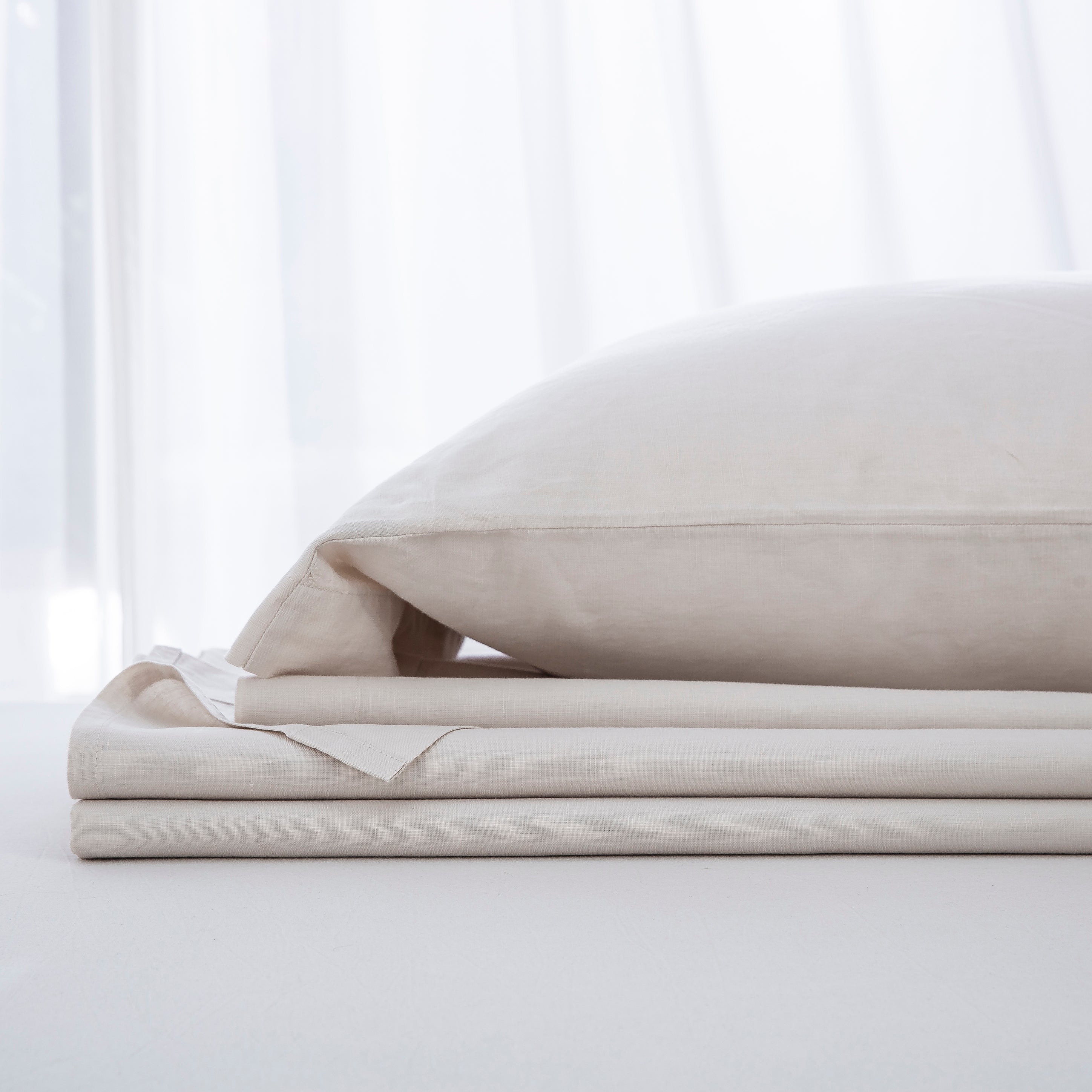 Complete natural oatmeal linen cotton bedding ensemble folded neatly showcasing a highly versatile foundation - DAUAOTO