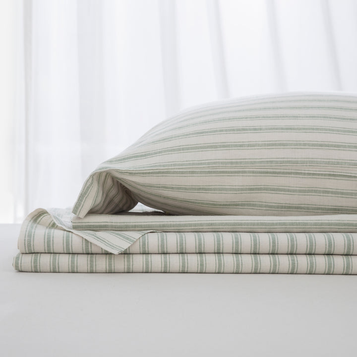 Complete sage green yarn-dyed stripe linen cotton bedding ensemble folded neatly showcasing a relaxed luxury sleep environment - DAUAOTO