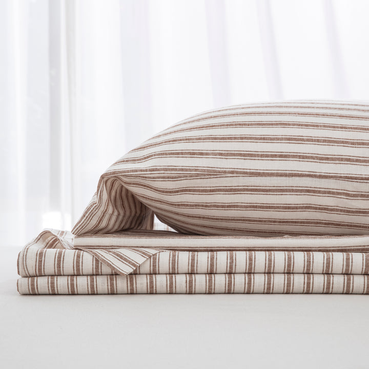 Complete taupe yarn-dyed stripe linen cotton bedding ensemble folded neatly showcasing quiet luxury and organic modern style - DAUAOTO