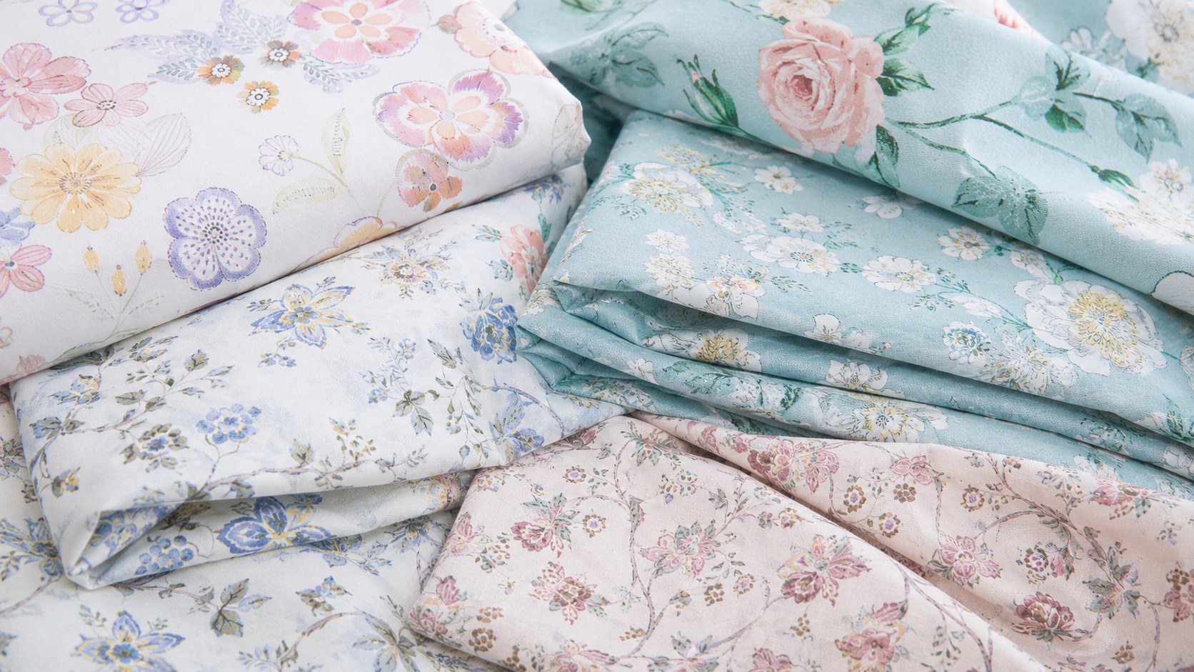 Folded pastel floral printed 100% cotton bedding fabrics for DAUAOTO duvet cover sets.