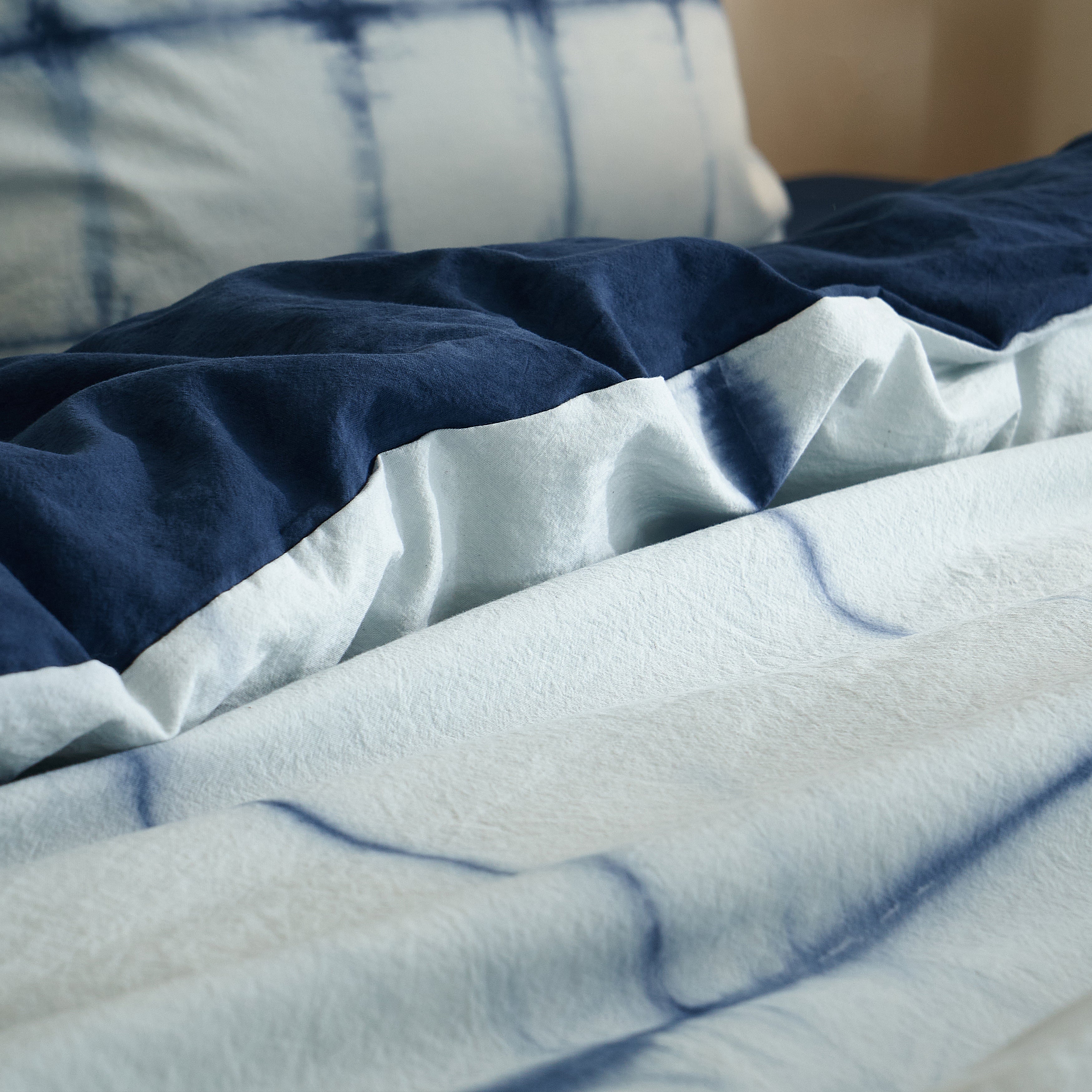 Close-up of the organic botanical indigo dye bleeding softly into the pure white cotton base
