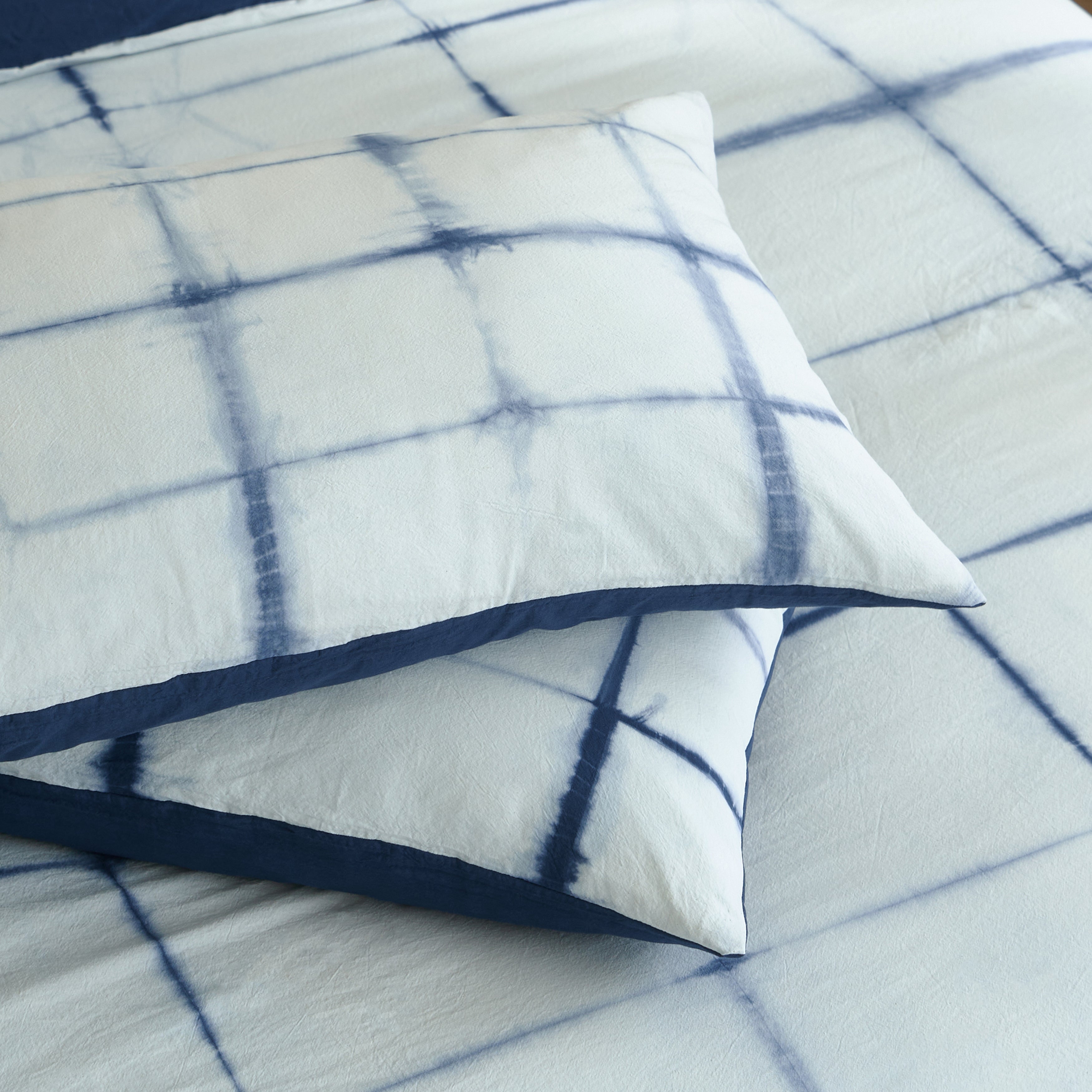 Two stacked DAUAOTO Artisan Grid 100% cotton pillowcases featuring casual intersecting indigo lines.