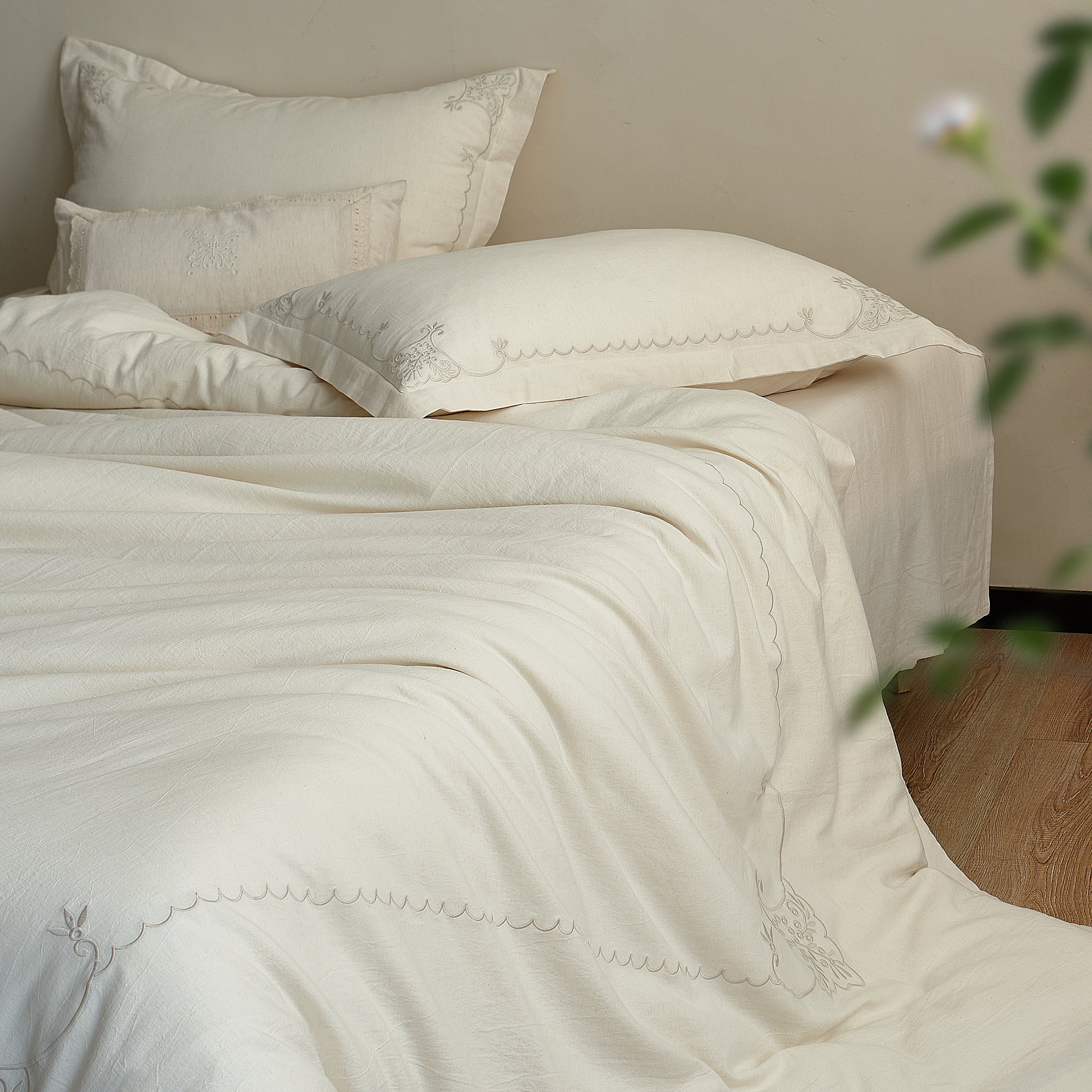 Side view of the Aveline embroidered duvet cover set with a relaxed natural drape.