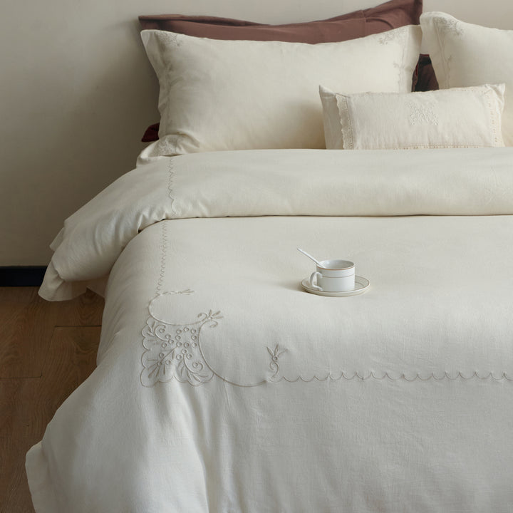Front view of the Aveline linen-cotton duvet cover set with coordinated pillow shams and ornamental embroidery.