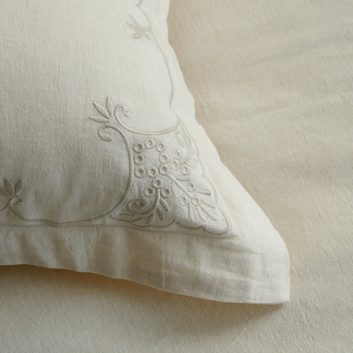 Close-up of the raised ornamental corner embroidery on an Aveline linen-cotton pillow sham.