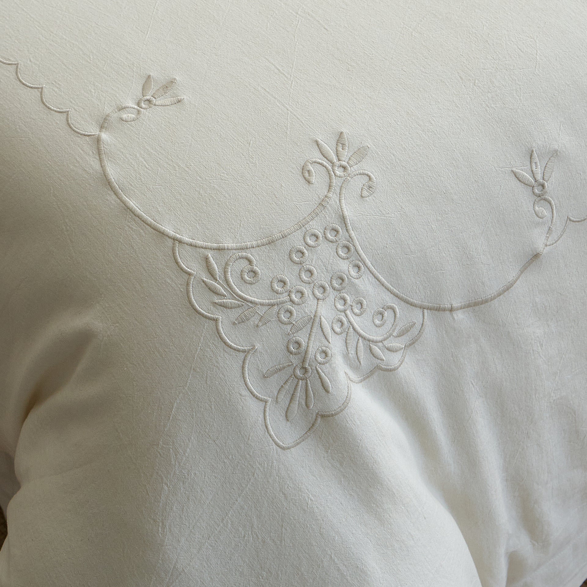 Close-up of the Aveline tone-on-tone ornamental embroidery on natural ivory linen-cotton fabric.