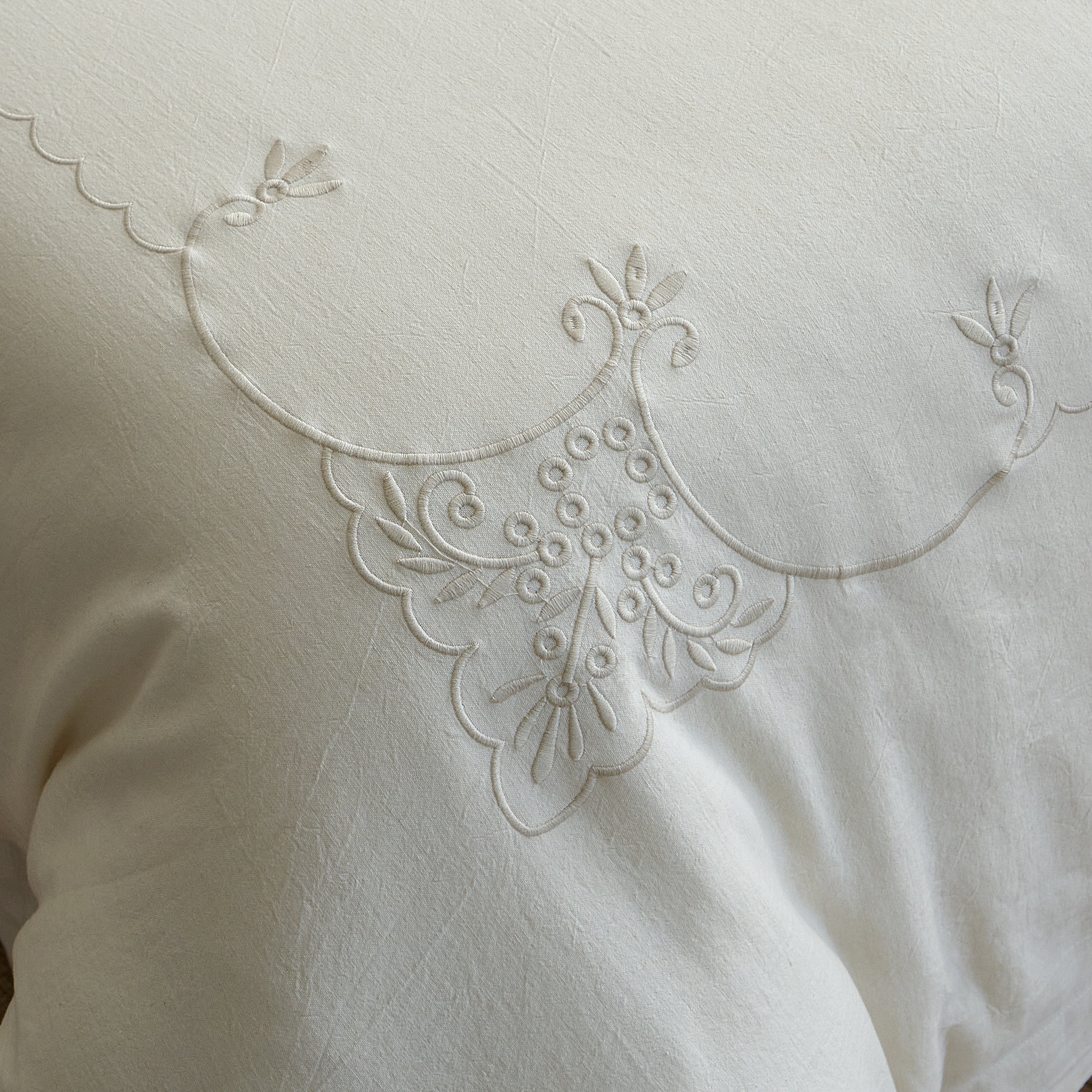 Close-up of the Aveline tone-on-tone ornamental embroidery on natural ivory linen-cotton fabric.
