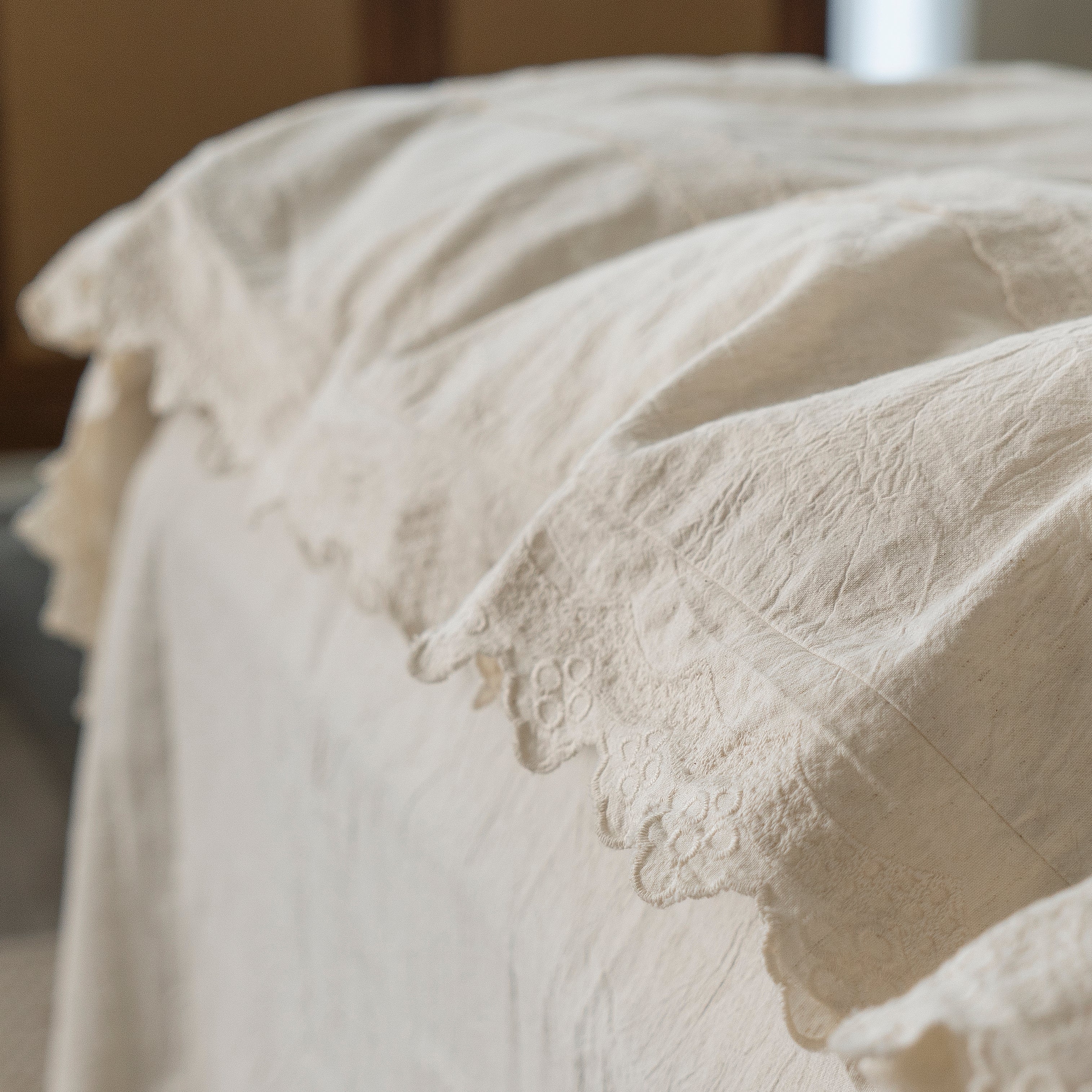 Close-up showing the elegant rounded corners and heavy, elegant drape of the Fontainebleau bedding.