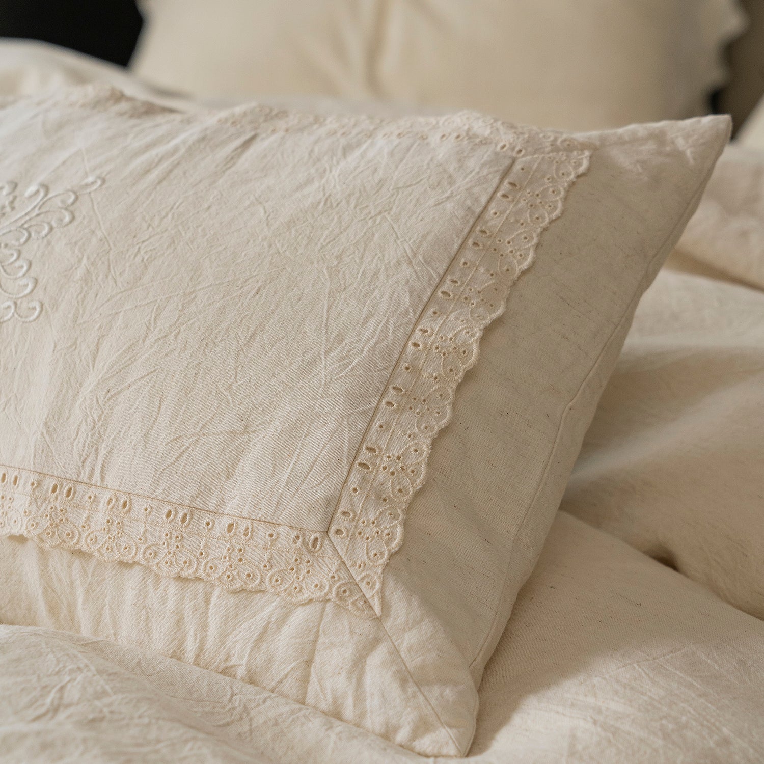 Detail shot of the heavy custom lace and vintage embroidery stitching on the Fontainebleau pillowcase edge.