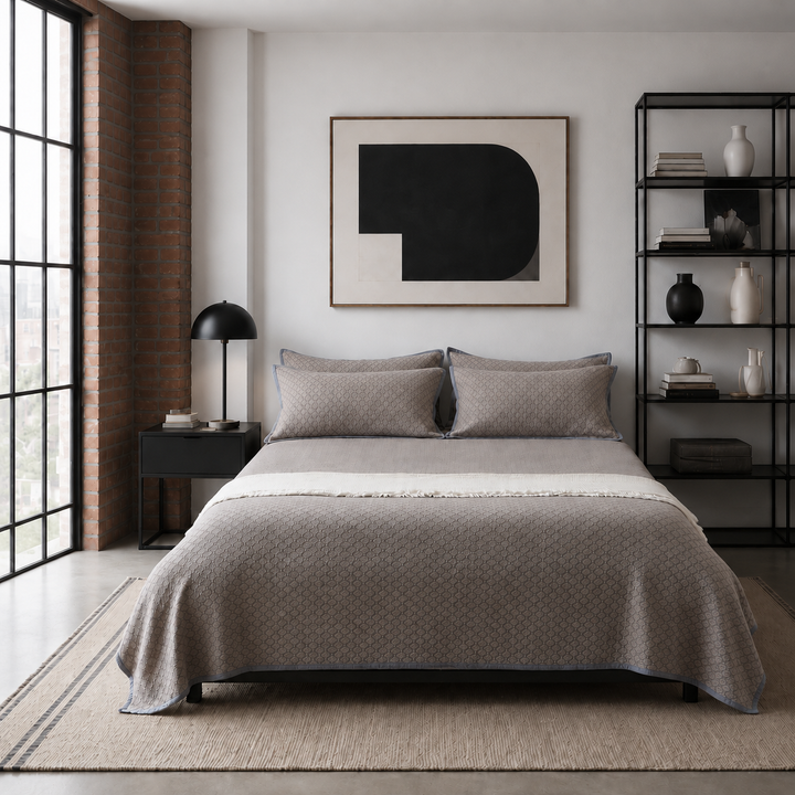 Front view of the warm taupe diamond jacquard coverlet set with matching pillow shams and dusty blue-gray trim.