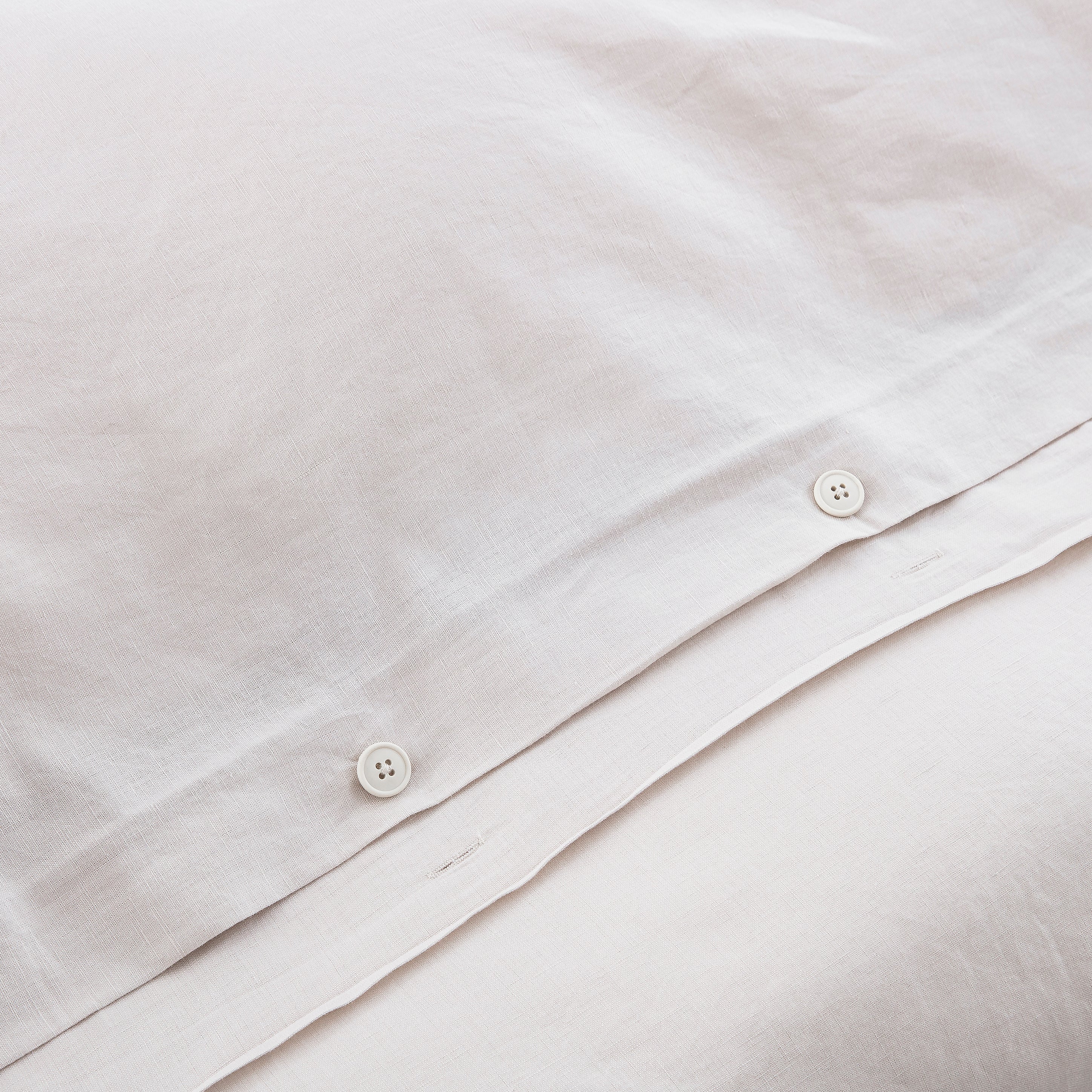 Discreet hidden button closure on the dove grey duvet cover representing traditional premium craftsmanship - DAUAOTO