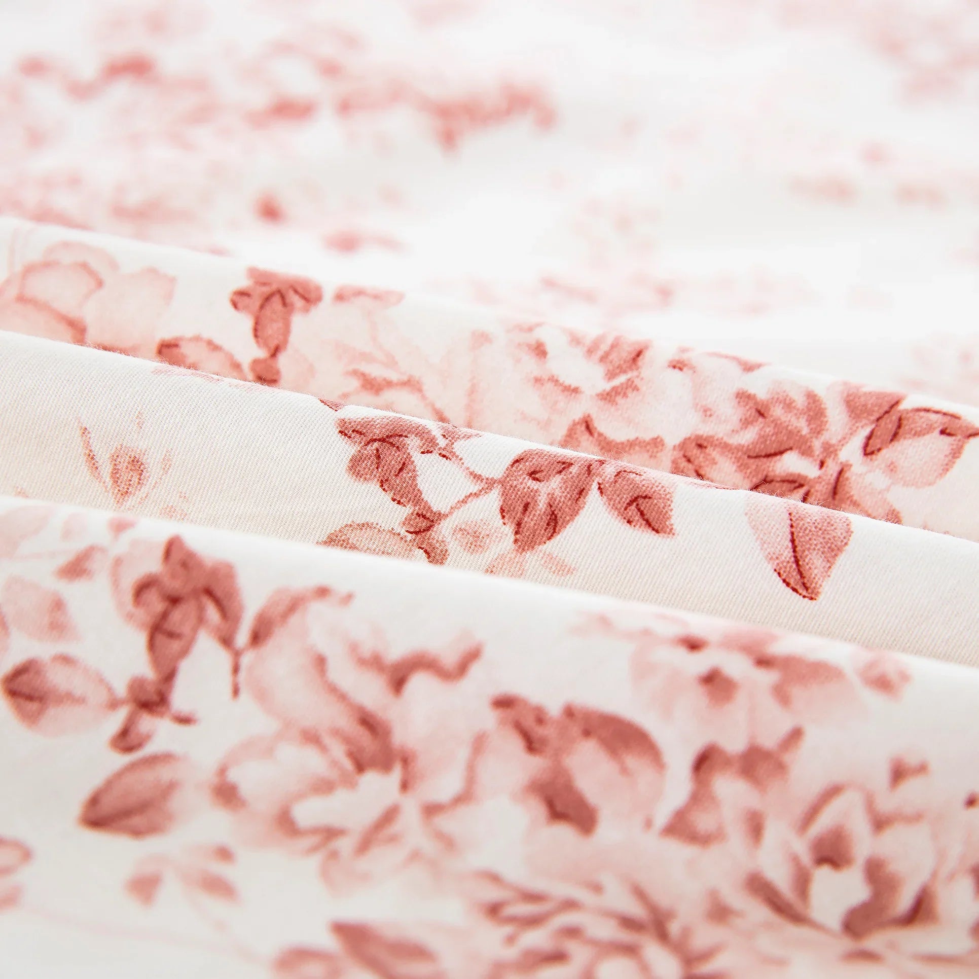 Close-up of the ultra-soft pure cotton fabric showing the dusty pink and soft rose floral pattern on a warm cream ground - DAUAOTO