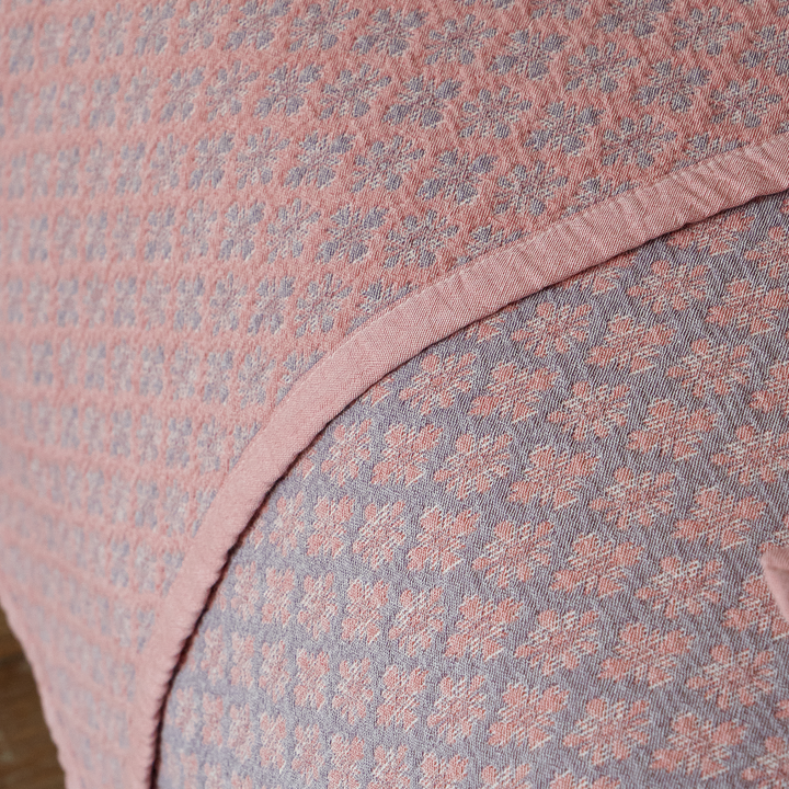 Detail shot of the tailored narrow bound edge on the heavyweight dusty rose cotton coverlet.