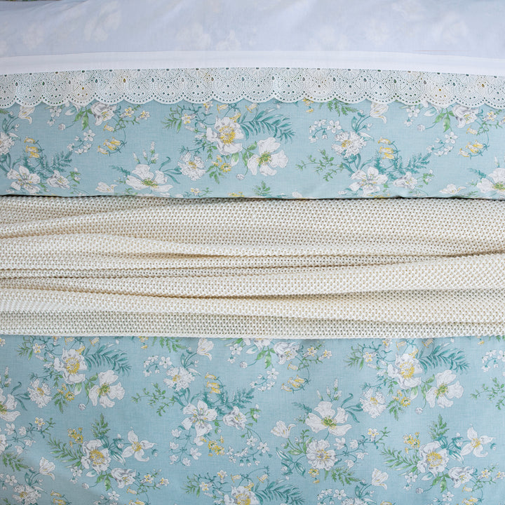 Close-up showing the elegant layered styling of the DAUAOTO light blue floral duvet cover set.