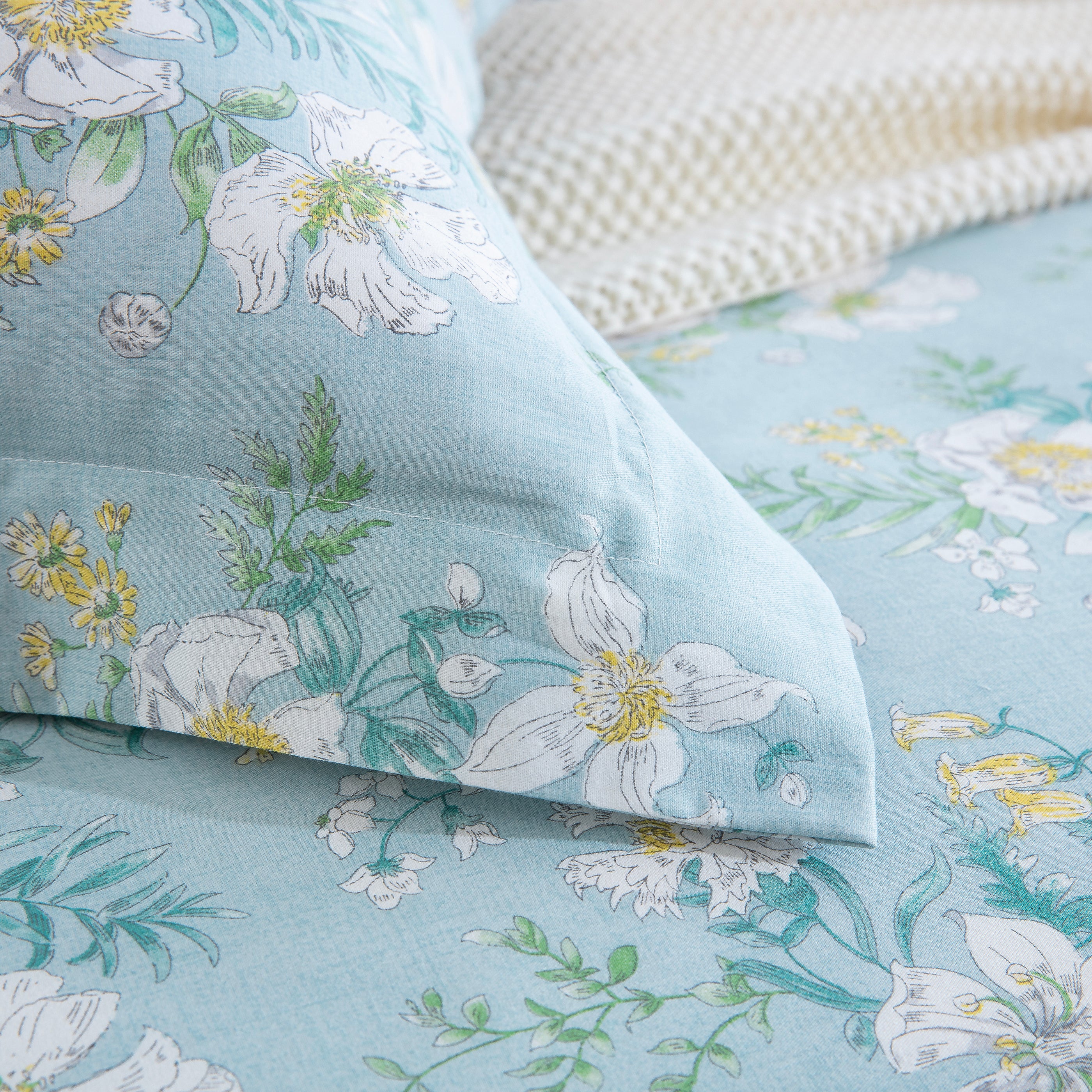 Detail of the DAUAOTO clear morning dew floral pillowcase corner resting on the matching lightweight duvet cover.
