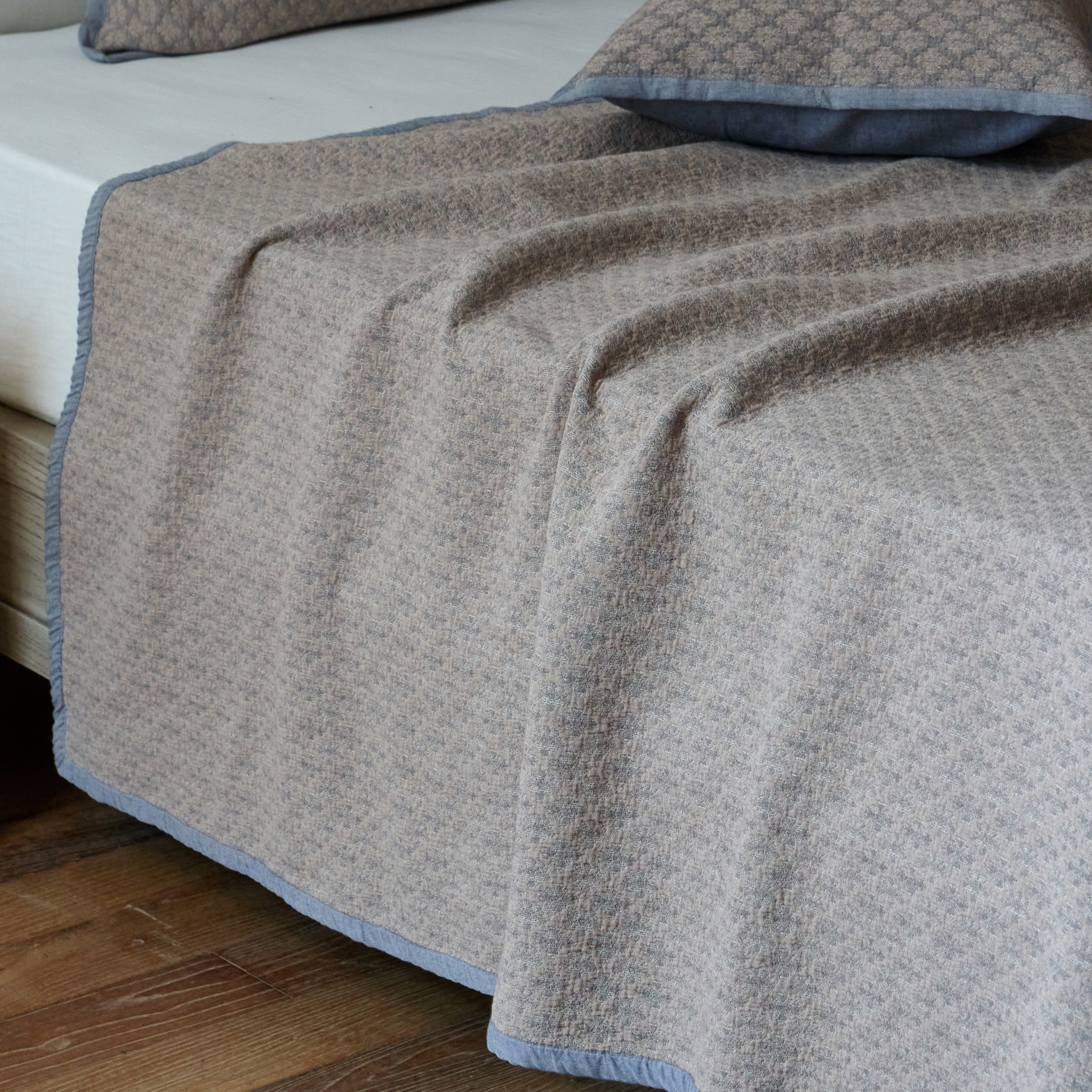 Beautiful heavyweight drape of the charcoal gray washed cotton coverlet cascading over the edge of the bed frame.