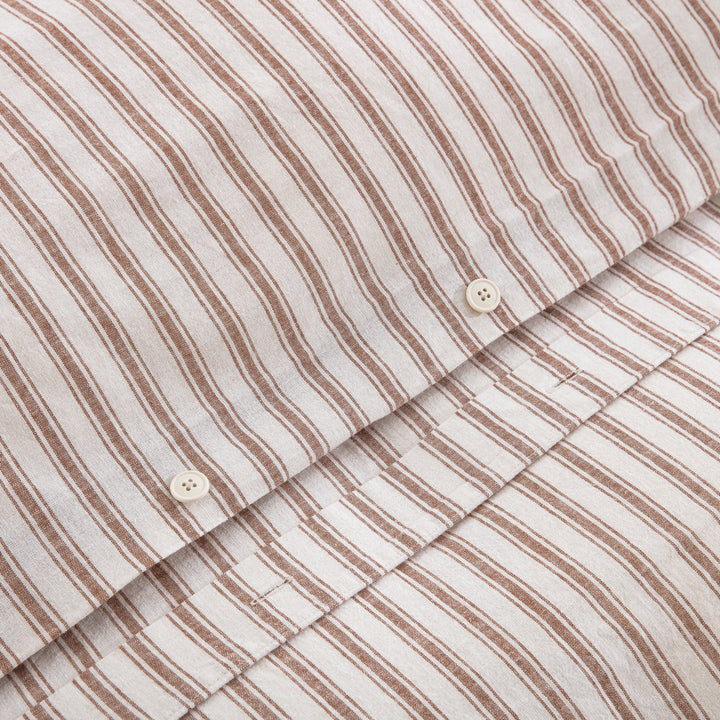 Premium craftsmanship showing a discreet hidden button closure on the caramel yarn-dyed stripe duvet - DAUAOTO