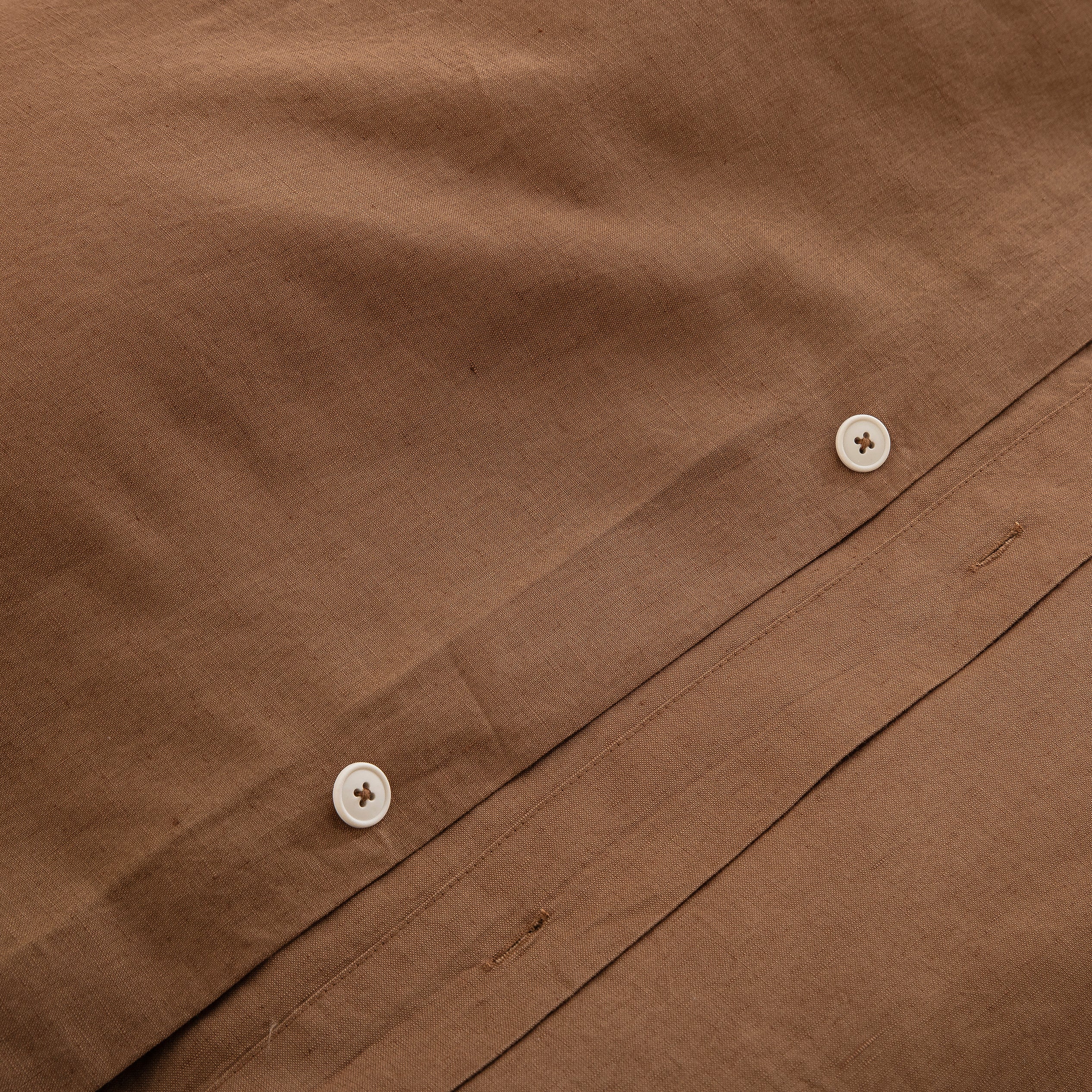 Premium traditional craftsmanship showing the discreet hidden button closure on the cognac brown linen duvet - DAUAOTO