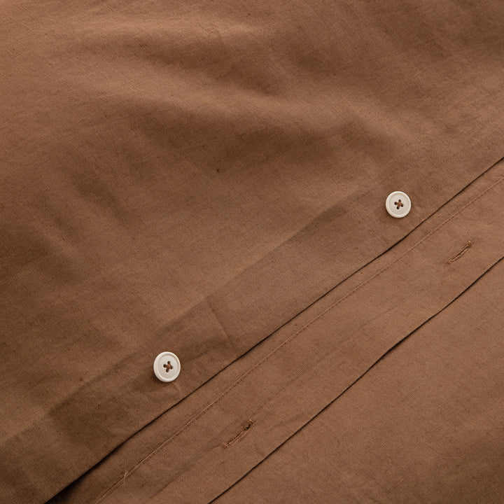 Premium traditional craftsmanship showing the discreet hidden button closure on the cognac brown linen duvet - DAUAOTO