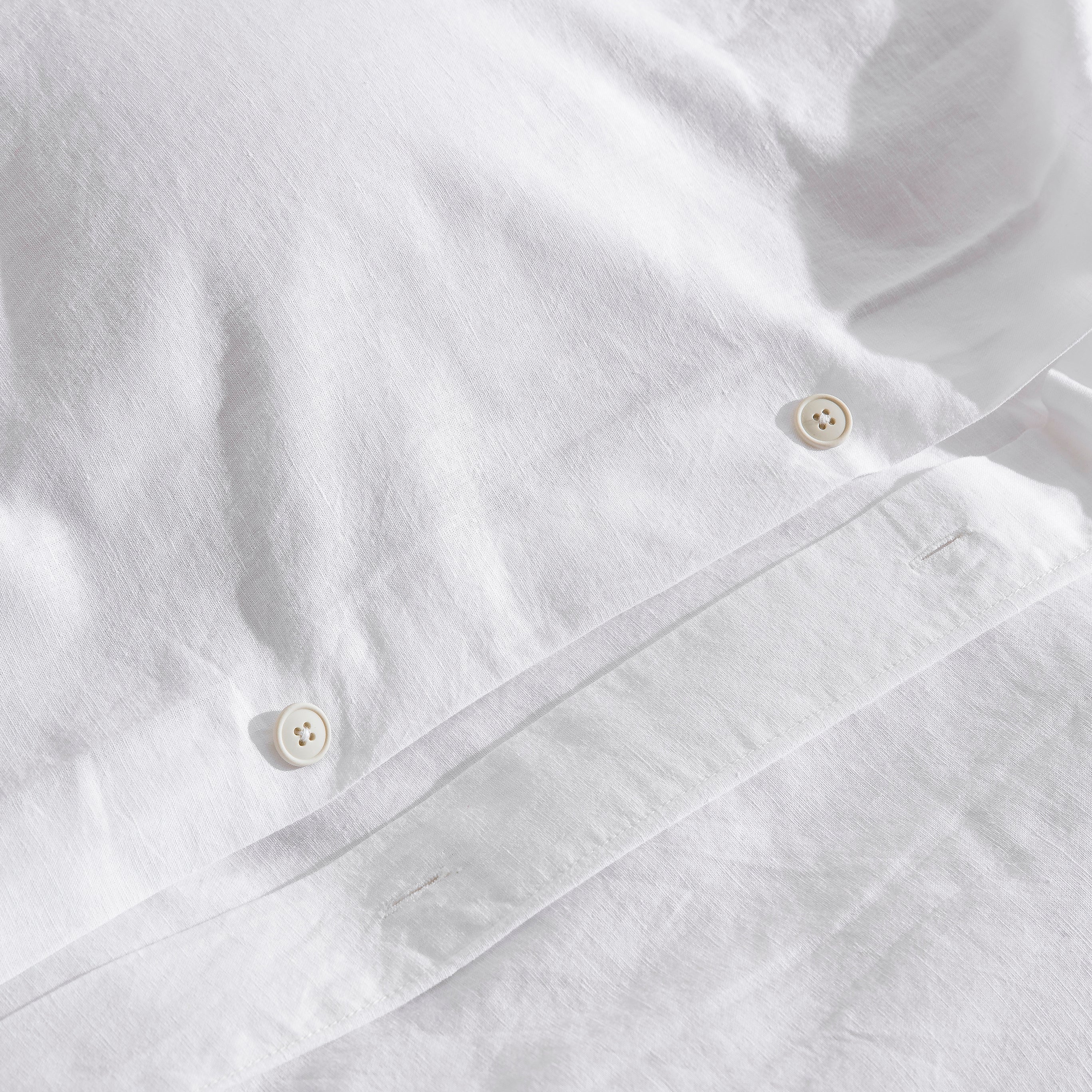 Premium traditional craftsmanship showing the elegant hidden button closure on white bedding - DAUAOTO