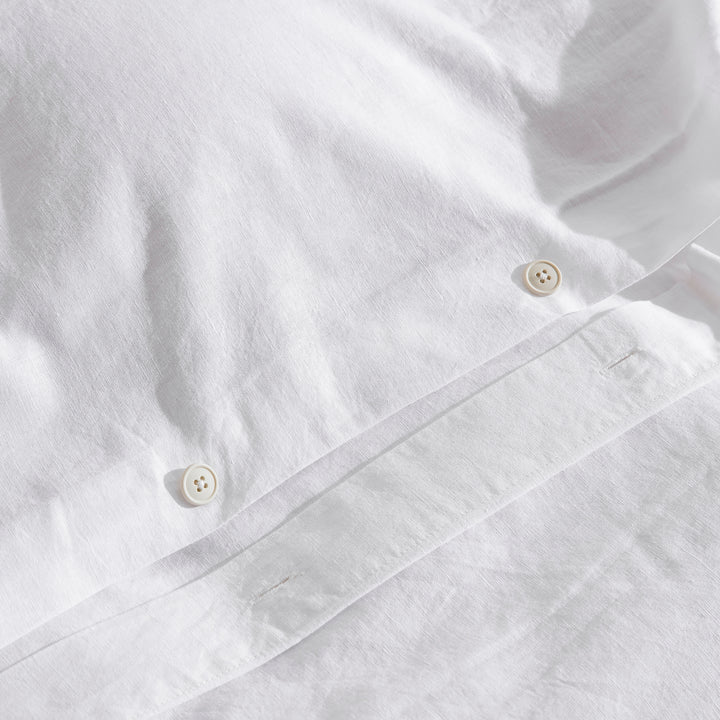 Premium traditional craftsmanship showing the elegant hidden button closure on white bedding - DAUAOTO