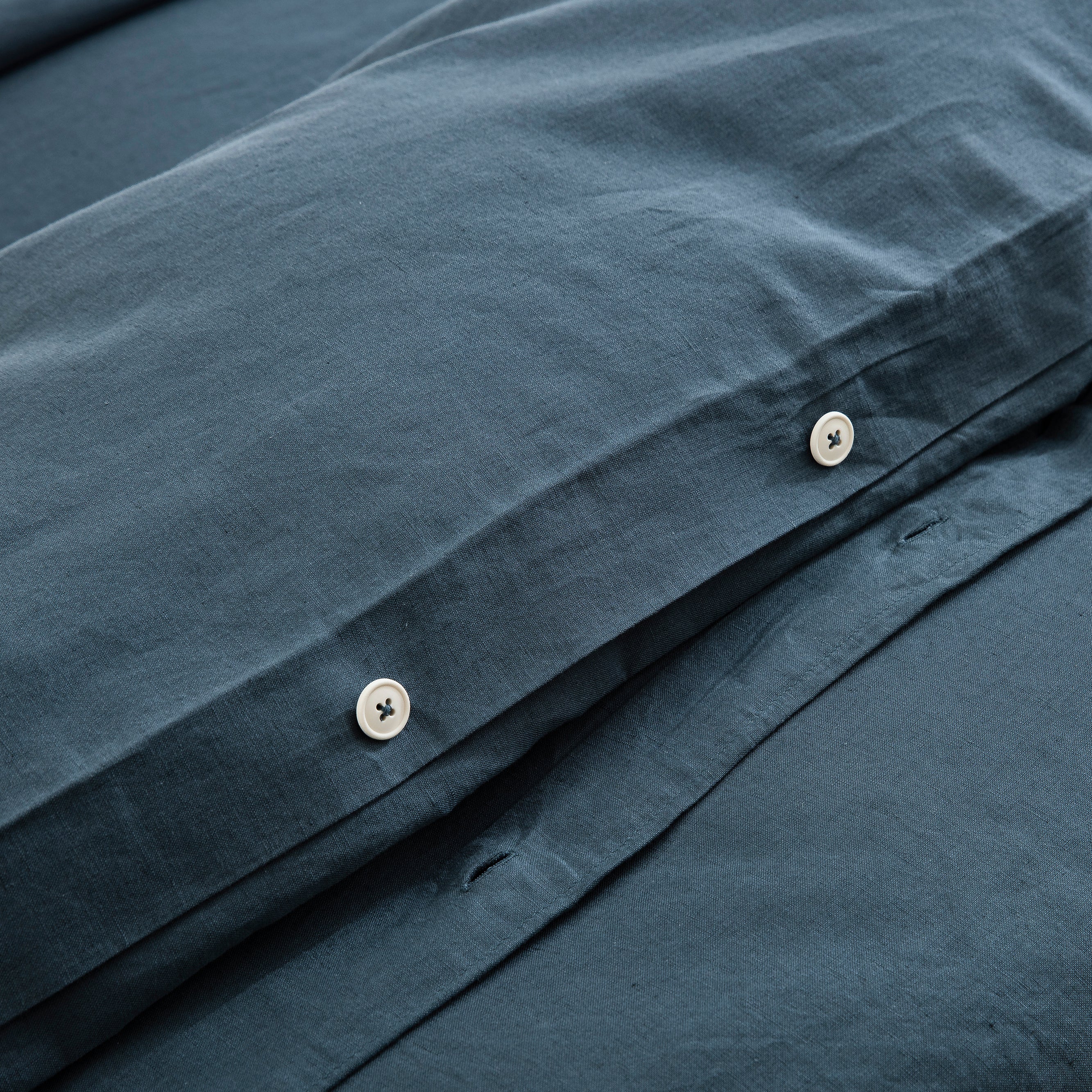 Discreet hidden button closure on the midnight slate blue duvet cover representing premium traditional craftsmanship - DAUAOTO
