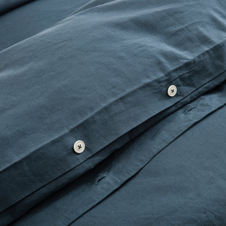 Discreet hidden button closure on the midnight slate blue duvet cover representing premium traditional craftsmanship - DAUAOTO