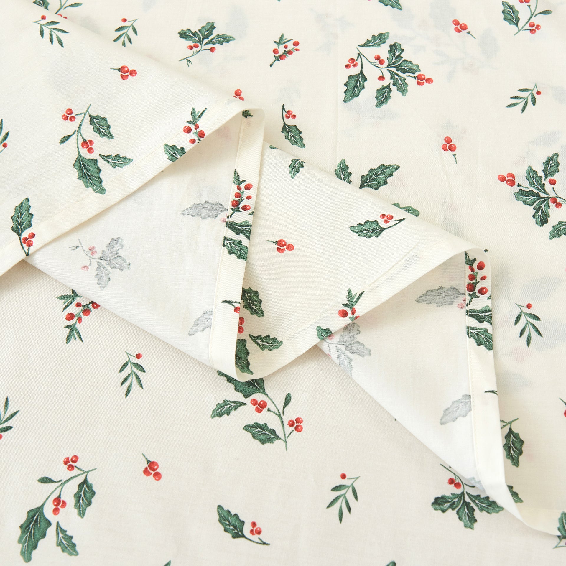 Close-up of the ultra-soft pure natural cotton fabric featuring green holly leaves and vibrant red berries - DAUAOTO