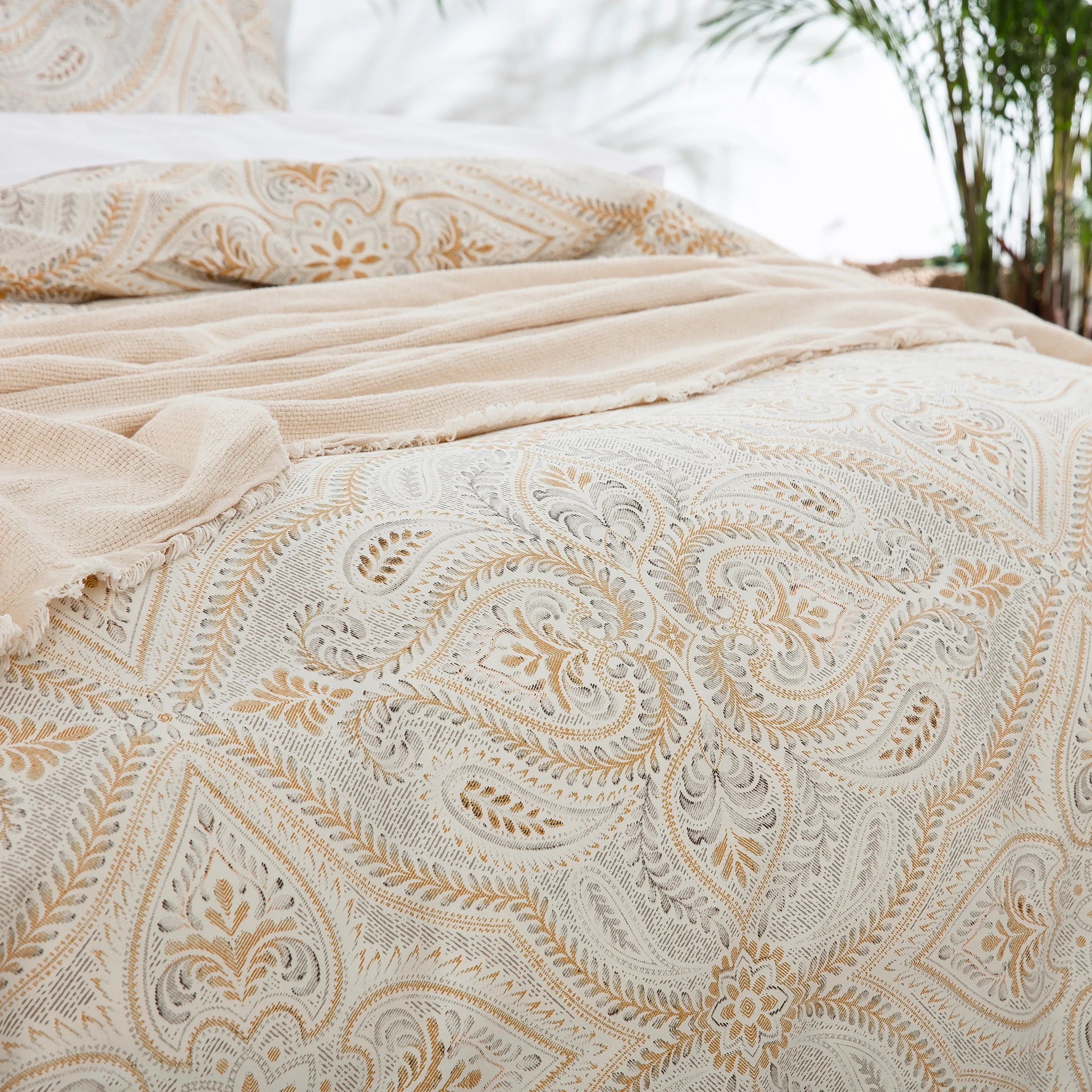 Close-up of elegant ivory and beige paisley medallion pattern on pure cotton bedding with throw blanket - DAUAOTO