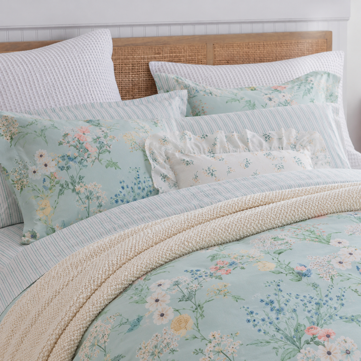 Neatly layered pillows on a bed, showcasing the DAUAOTO mint breeze floral pattern and lightweight cotton texture.