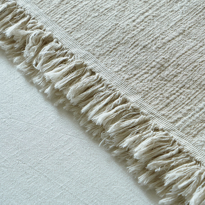 blanket-fringe-edge-detail.jpg	Detailed close-up of the fringe and subtle dashed jacquard pattern on a light greige cotton-linen blanket.