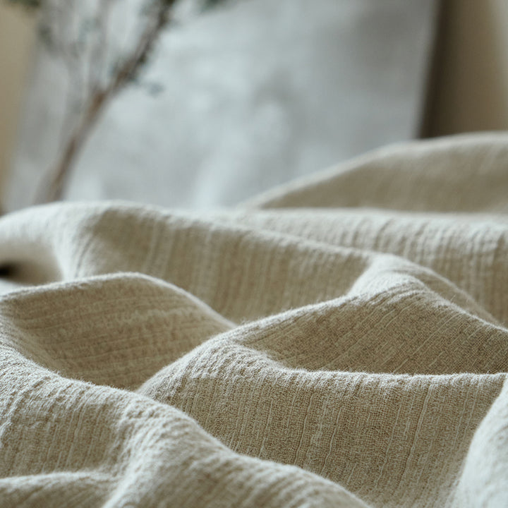 Close-up of the breathable light greige linen blend fabric showing its natural crinkle and dashed woven texture.