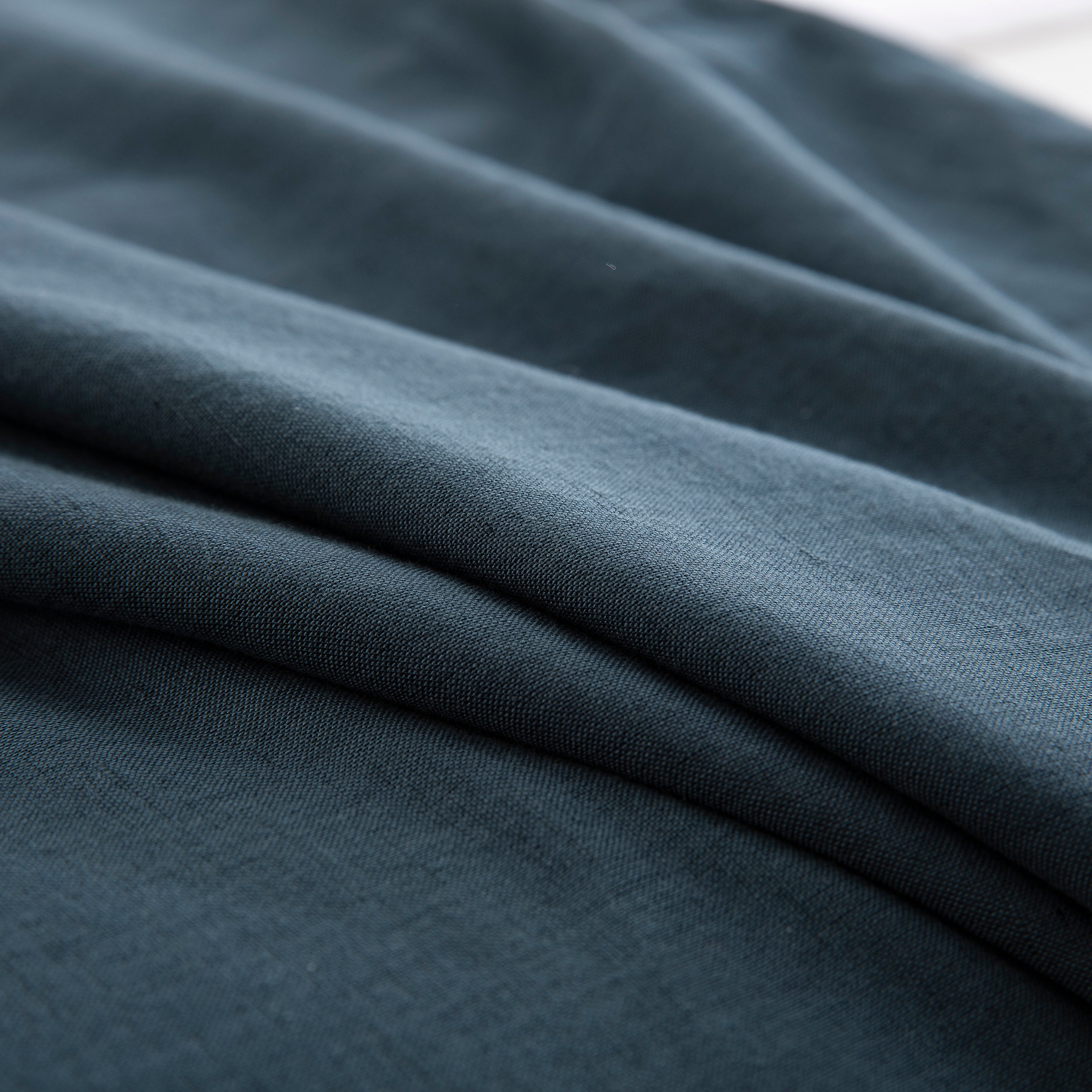 Close-up of the calming blue-grey tone and soft texture of the midnight slate blue linen cotton blend - DAUAOTO