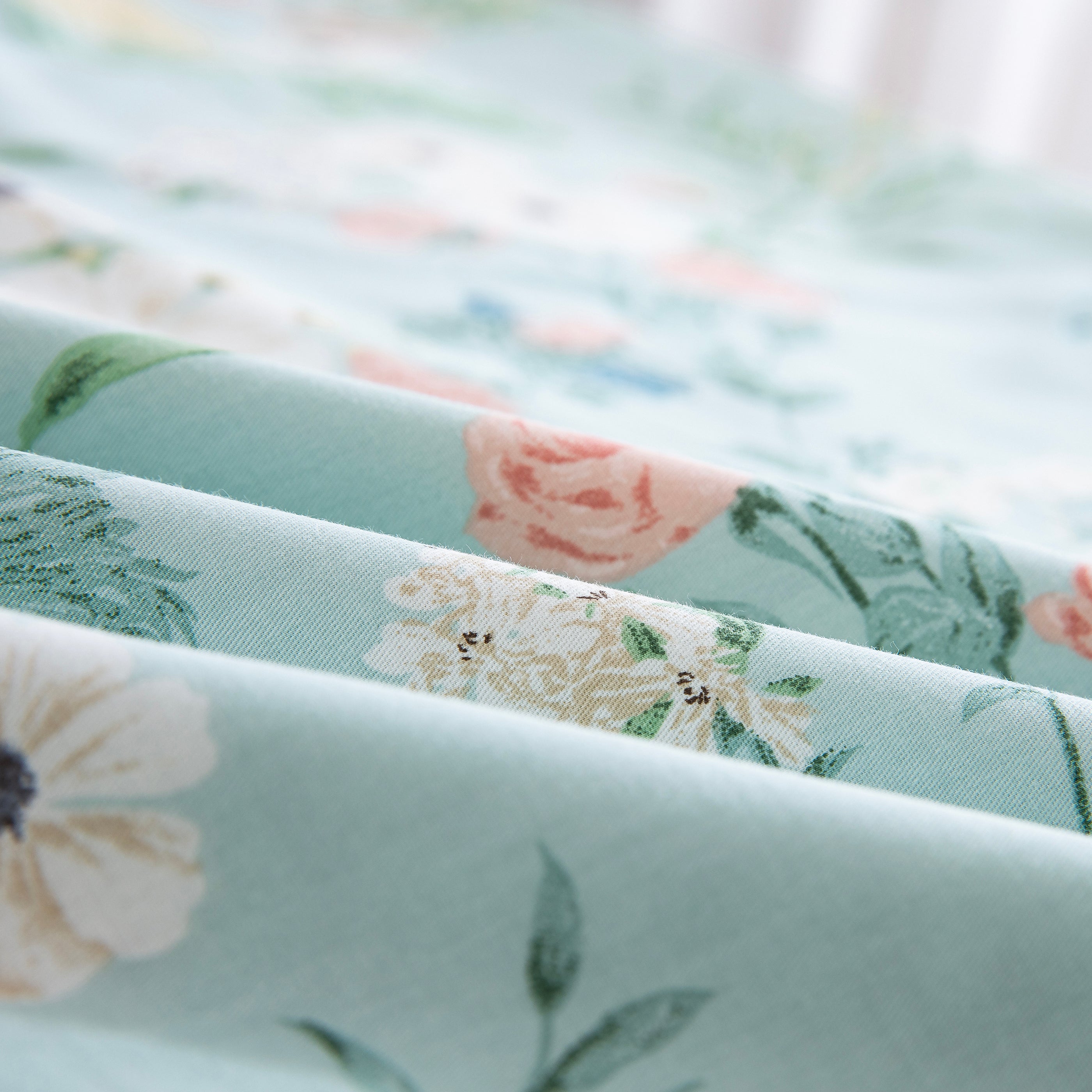 Close-up of DAUAOTO lightweight cotton fabric featuring a mint green base with delicate pink and white wildflower print.