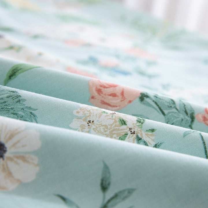 Close-up of DAUAOTO lightweight cotton fabric featuring a mint green base with delicate pink and white wildflower print.