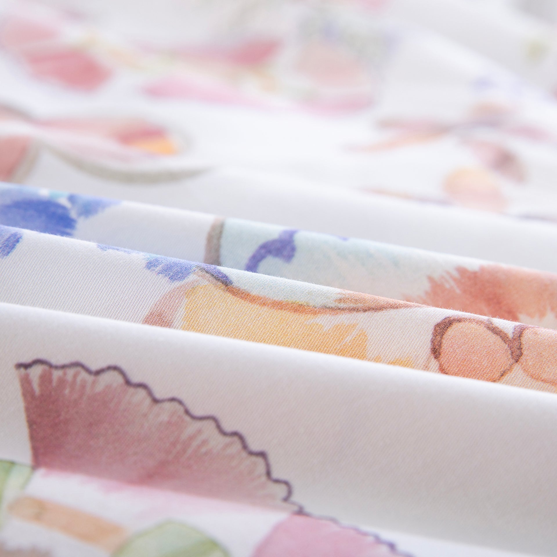 Close-up of DAUAOTO lightweight cotton fabric featuring a bright pastel watercolor floral print.