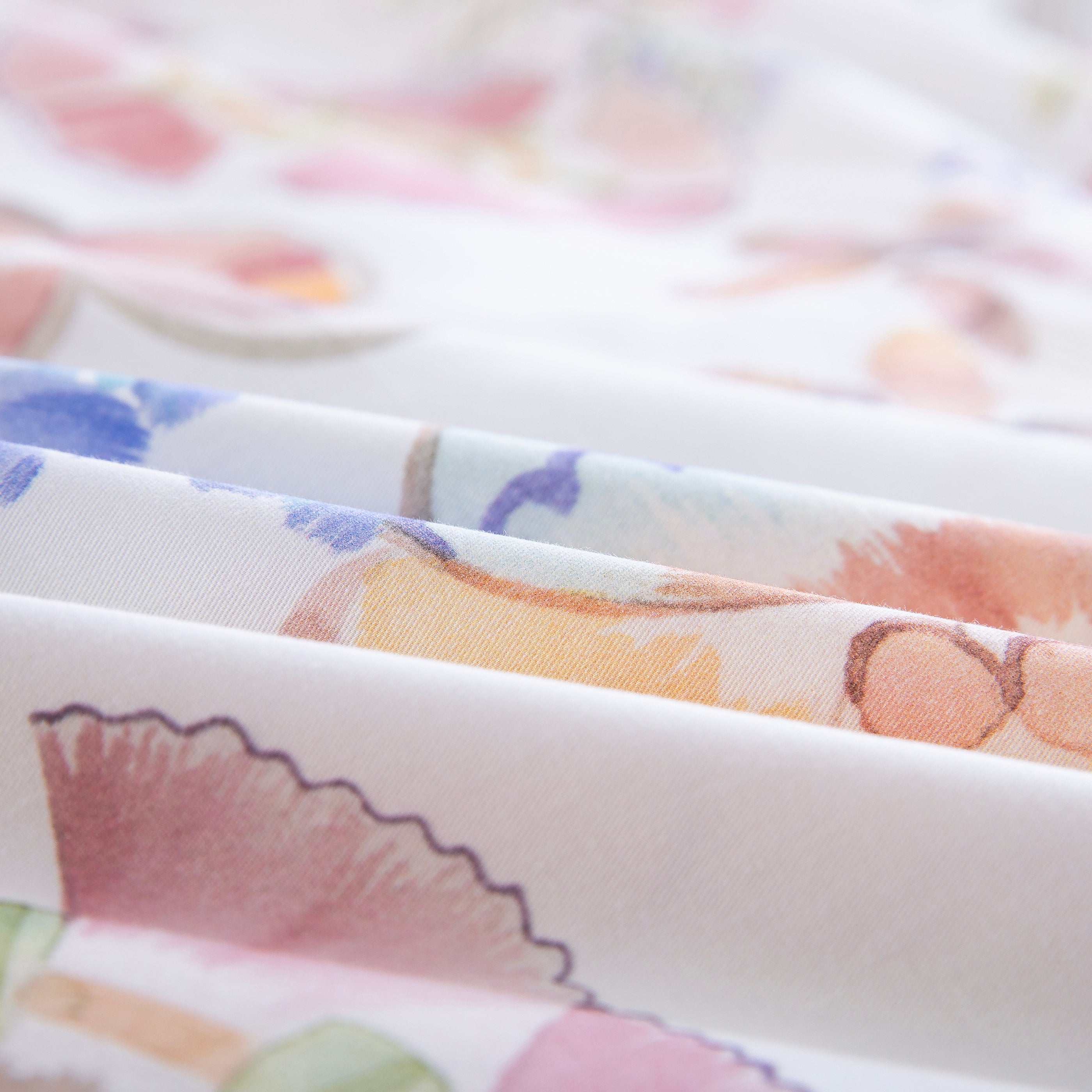 Close-up of DAUAOTO lightweight cotton fabric featuring a bright pastel watercolor floral print.