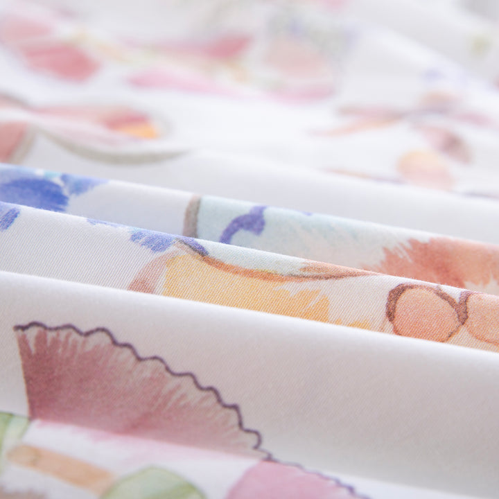 Close-up of DAUAOTO lightweight cotton fabric featuring a bright pastel watercolor floral print.