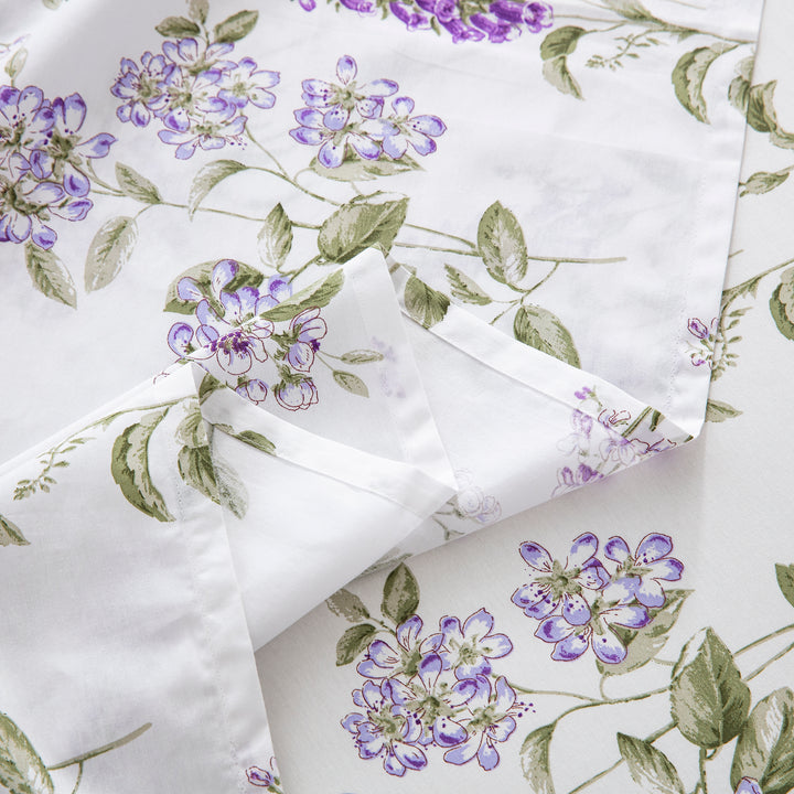 Detailed view of the exquisitely soft flat sheet hem featuring the romantic lilac botanical print to brighten up a guest room - DAUAOTO