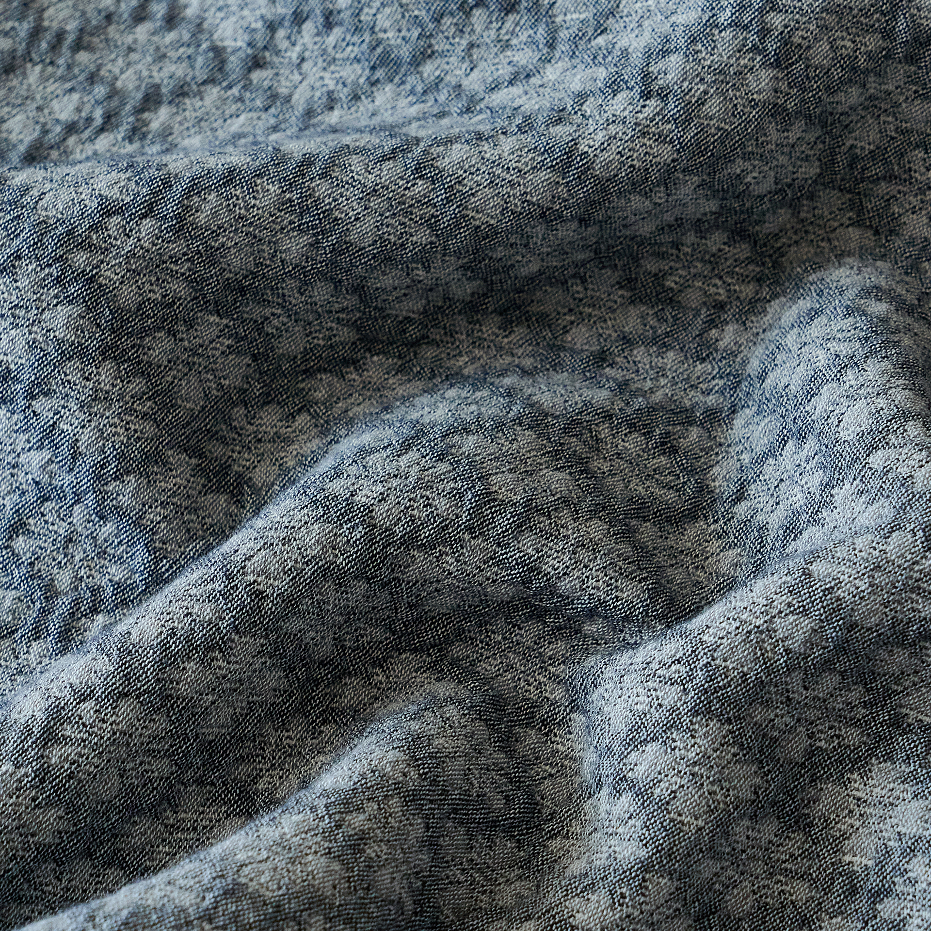 Close-up of the slate blue 3D yarn-dyed diamond jacquard fabric showing natural washed wrinkles.